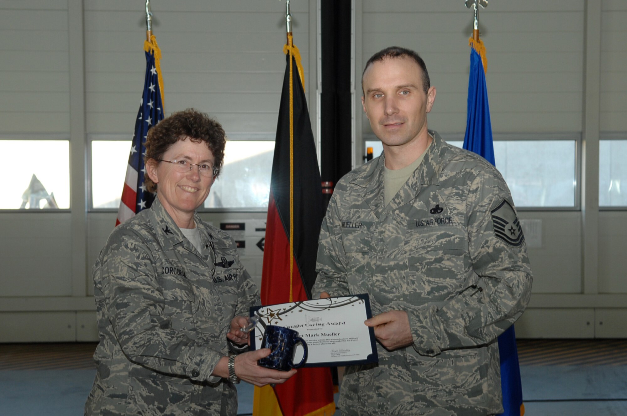 Col. Kimberly Corcoran, 521st  Air Mobility Operations Wing commander presents Master Sgt. Mark Mueller with the Shining Star award Ramstein Air Base, Germany, Feb. 19, 2009. Sergeant Mueller has gone beyond the call of duty in support of a fellow airmen and his family, following the airmen's involvement in an automobile accident that left him in crital condition. (Air Force photo by Airman 1st Class Tony R. Ritter)