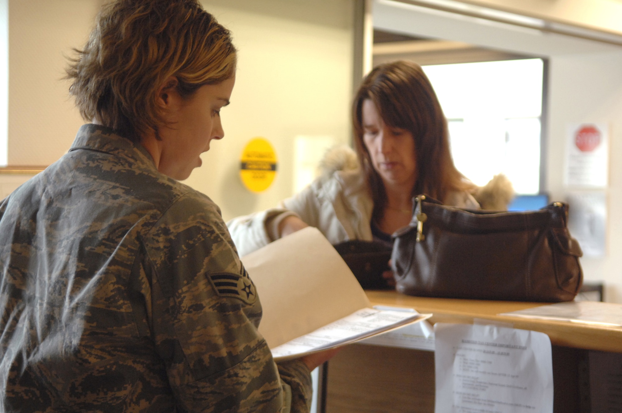 Senior Airman Amanda O'Hara, 435th Air Base Wing paralegal, assists a law center customer with Power of Attorney documents.  Airman O'Hara, a Charlotte N.C. native, joined the Air Force four years ago and has enjoyed nearly every minute of it. (Air Force photo by Tech. Sgt. Michael Voss)