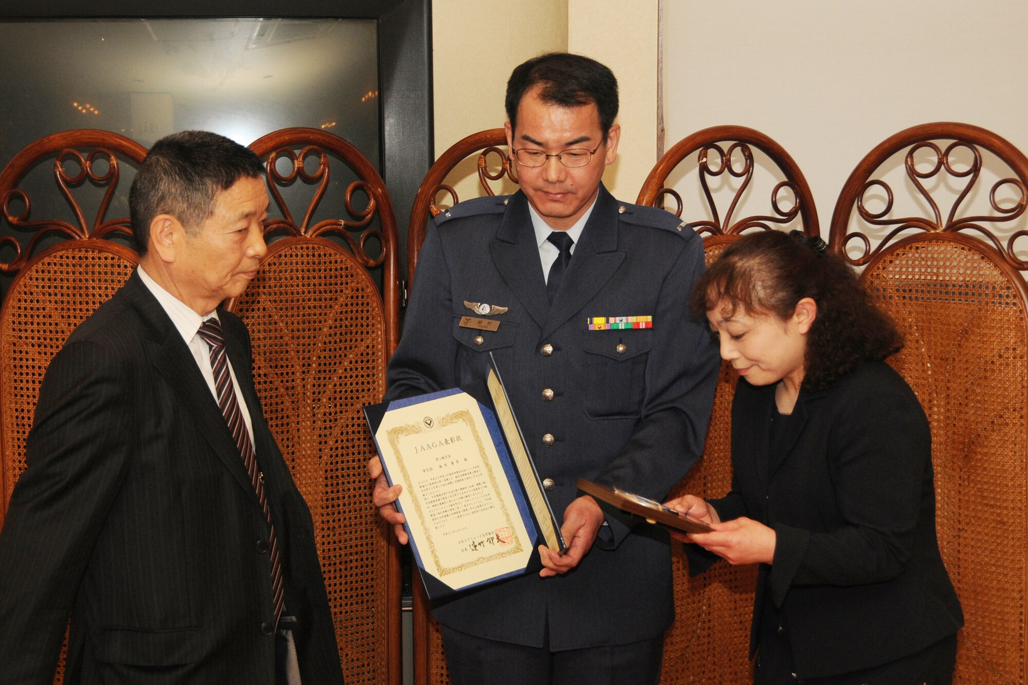 MISAWA AIR BASE, Japan -- Warrant Officer Yasuo Iimura, 3rd Air Wing, and his wife, Taeko, receive a Japan-America Air Force Goodwill Association award from Japan Air Self-Defense Force retired Gen. Ikuo Tohtake Feb. 20, 2009. Warrant Officer Iimura was recognized for his contributions as NCO Association president of Misawa Air Base. (U.S. Air Force photo by Senior Airman Jamal D. Sutter)