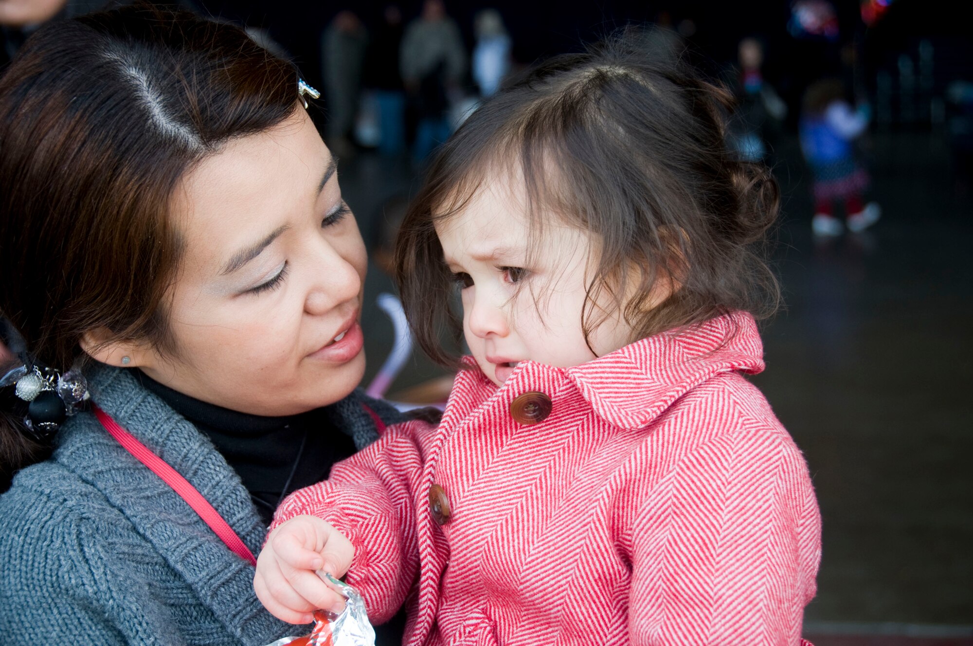 MISAWA AIR BASE, Japan -- Nao Kauffman calms her daughter, Abby, while waiting for Tech. Sgt. Andrew Kauffman, 35th Aircraft Maintenance Squadron, to arrive home from a six-month deployment March 1, 2009. Hundreds of family members gathered to greet 275 Airmen returning from a deployment to Joint Base Balad, Iraq. (U.S. Air Force photo by Staff Sgt. Rachel Martinez)