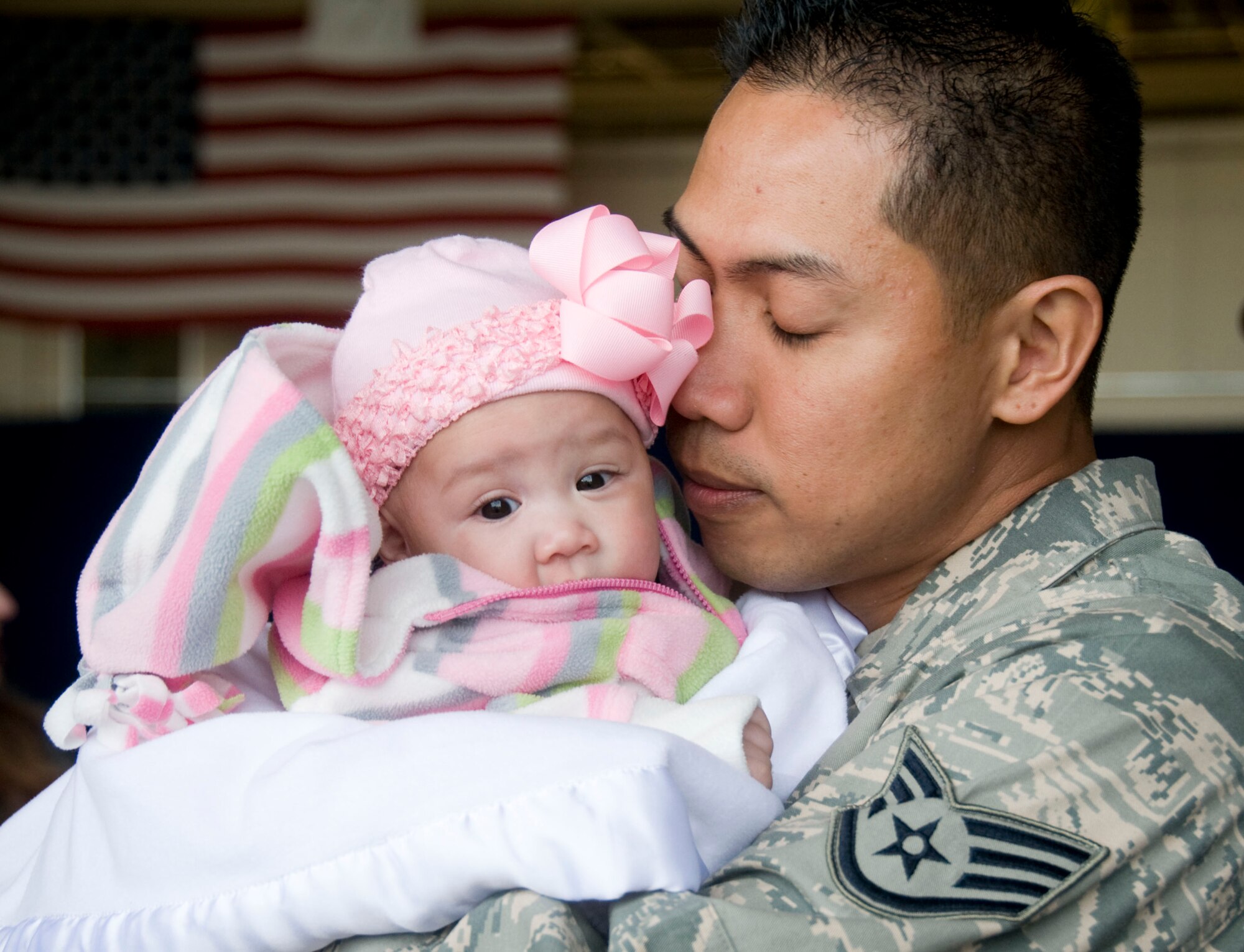 MISAWA AIR BASE, Japan -- Staff Sgt. Dennis Horlador, 35th Operations Group, embraces his newborn, Natyala, after returning home March 1, 2009. Sergeant Horlador missed the birth of his daughter while deployed to Joint Base Balad, Iraq. (U.S. Air Force photo by Staff Sgt. Rachel Martinez)