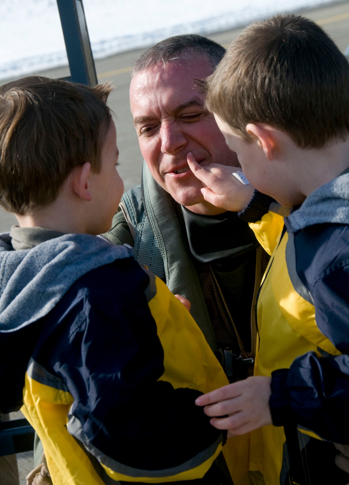 MISAWA AIR BASE, Japan -- Lt. Col. Shane Riza, 14th Fighter Squadron commander, is greeted by his two sons after returning to Misawa Feb. 27, 2009. Colonel Riza deployed with the 14th FS to Joint Base Balad, Iraq, for five months. (U.S. Air Force photo by Staff Sgt. Rachel Martinez)