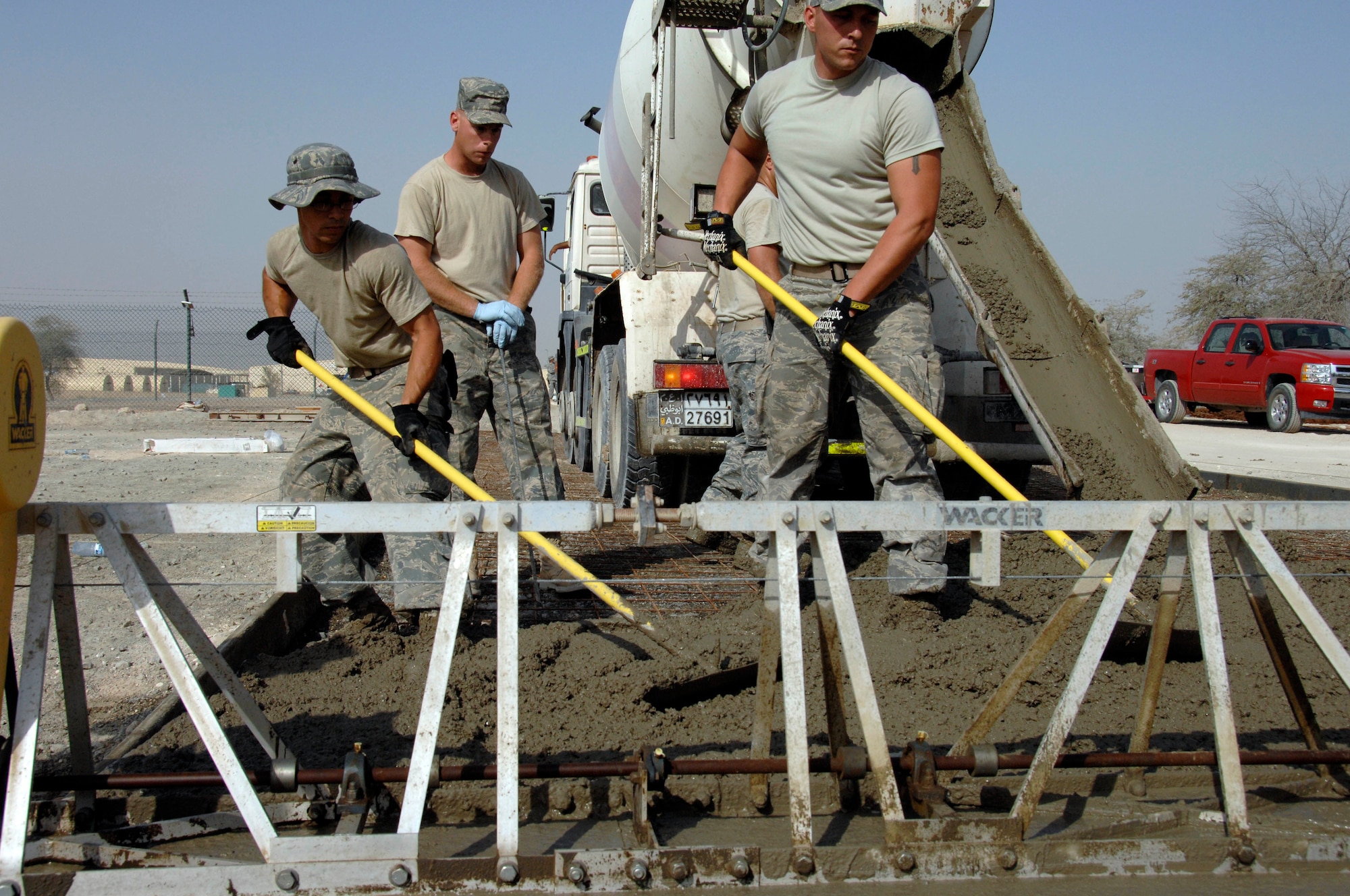 SOUTHWEST ASIA -- Airman 1st Class Francisco Bautista, from the 380th Expeditionary Civil Engineering Squadron, smooths concrete for the foundation of a new gym here. This is Airman Bautista's first deployment. (U.S. Air Force photo by Staff Sgt. Mike Andriacco) (Released)
