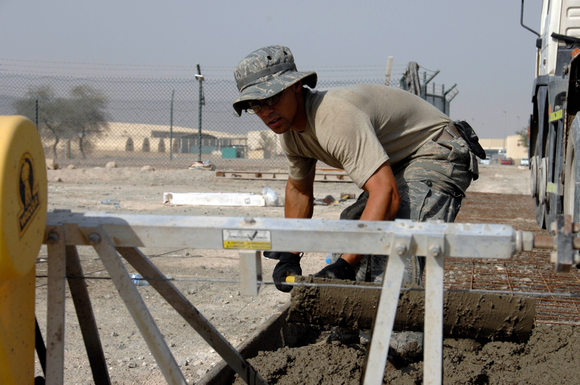 SOUTHWEST ASIA -- Airman 1st Class Francisco Bautista, from the 380th Expeditionary Civil Engineering Squadron, smooths concrete for the foundation of a new gym here. This is Airman Bautista's first deployment. (U.S. Air Force photo by Staff Sgt. Mike Andriacco) (Released)