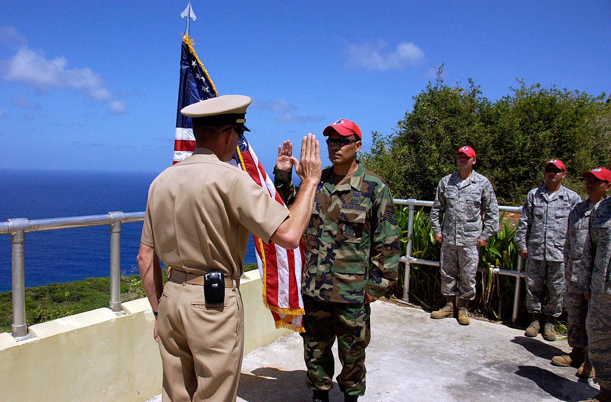 ANDERSEN AIR FORCE BASE, Guam -- Navy Lt. Cmdr. Willis Arnold, Naval Computer and Telecommunications Station, Guam executive officer, reenlists Air Force Tech. Sgt. Andrew Campos, 554th RED HORSE Squadron noncommissioned officer in charge, electrical section, Mar. 2 at the Tarague overlook here. This reenlistment is Sergeant Campos's third reenlistment with the Air Force. (U.S. Air Force photo by Airman 1st Class Carissa Wolff)                              