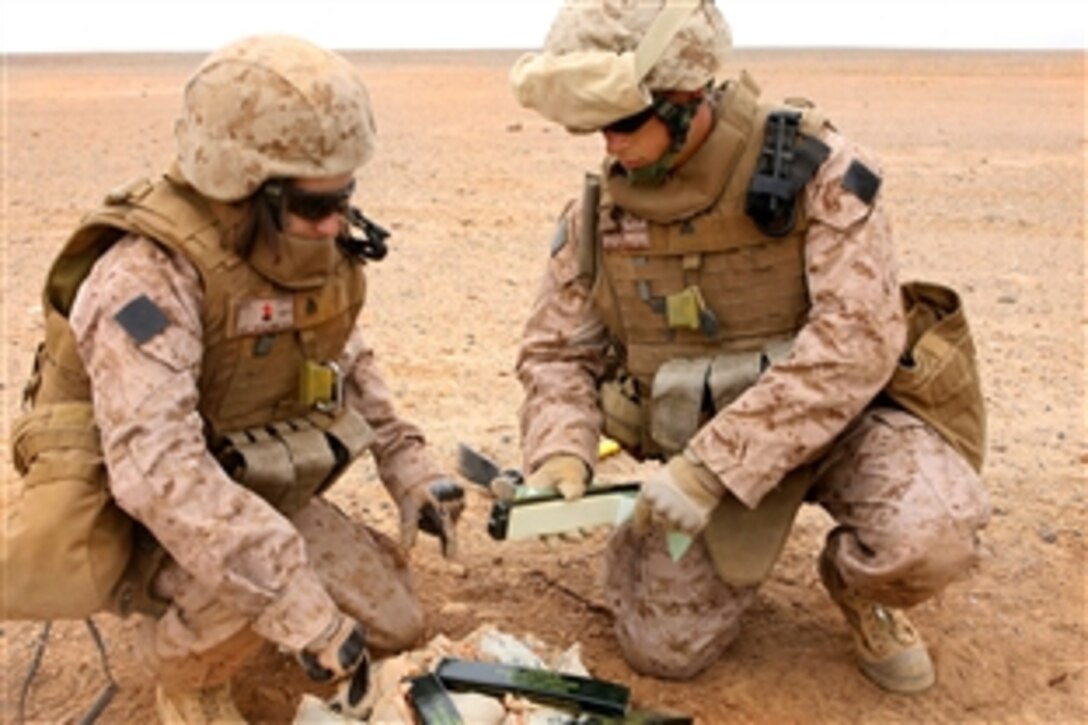 U.S. Marine Corps Sgt. Chanel S. Wolter, left, and Cpl. Victor M. Gallegos place composition C-4 plastic explosives on unserviceable ordnance during training at a demolition range on Camp Bastion, Afghanistan, Feb. 21, 2009. Wolter, an ammunition technician, and Gallegos, a traffic management office expediter, are assigned to Headquarters Company, Combat Logistics Battalion 3.