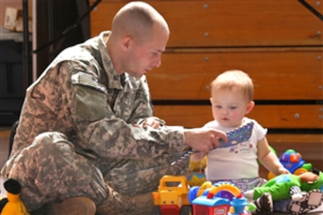 U.S. Army Pfc. Brian Cross plays with his 10-month-old daughter Mah-lee Ann during a send-off on Fort Bliss, Texas, Feb. 28, 2009. Cross, assigned to the 591st Military Police Company, is bound for Iraq.