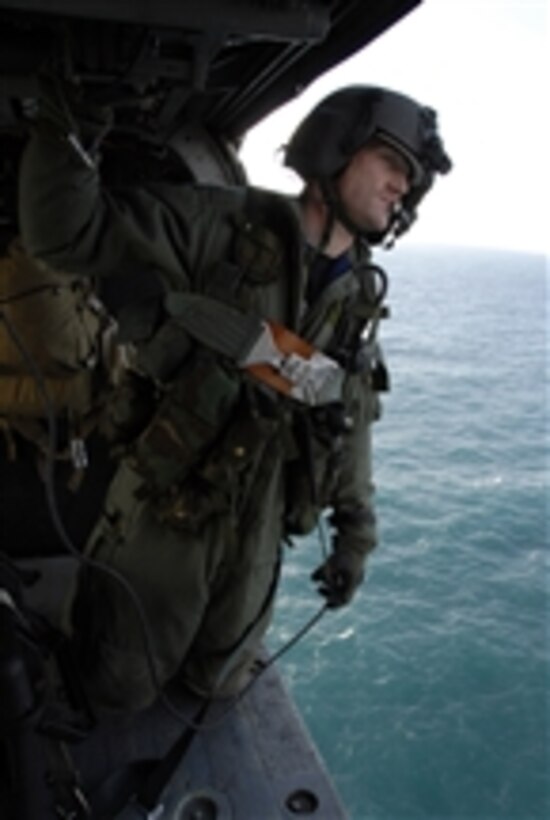 U.S. Air Force Staff Sgt. Joseph Kenney, an HH-60G Pave Hawk flight engineer assigned to the 129th Rescue Wing of the California Air National Guard, observes his surroundings for flight safety over Farallon Island, Calif., on Feb. 17, 2009.  The unit is supporting the U.S. Fish and Wildlife Service by delivering photovoltaic batteries to power a lighthouse and workshop on the island.  