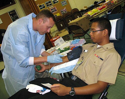 ANDERSEN AIR FORCE BASE, Guam -- Army Sgt. Patrick Goble, Armed Forces Blood Bank Center prepares to draw blood from Seaman Muhammad Falah, U.S. Naval Hospital, Guam fleet liaison, during the blood drive at the Chapel One Annex March 3. The Armed Forces Blood Bank Center is a joint service operation, with all branches of the military in its program. (U.S. Air Force photo by Airman 1st Class Carissa Wolff)