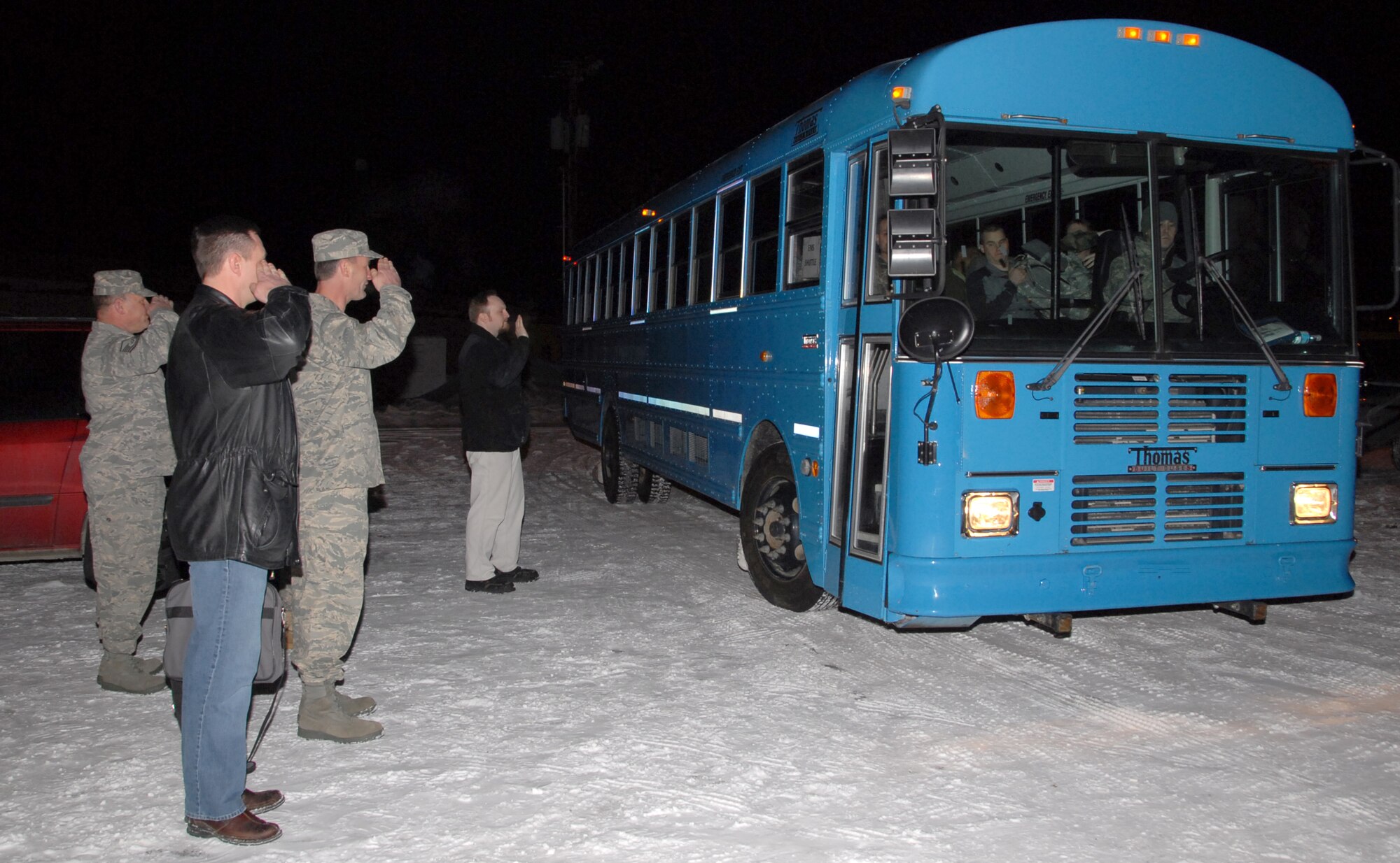 ELMENDORF AIR FORCE BASE, Alaska -- Colonel Eric Overturf, Commander of the 477th Fighter Group and members of the 477th Civil Engineer Squadron salute the departing bus as the 477 CES leaves for their deployment Monday night. This is the first deployment for the 477 CES since World War II.  They are the only Air Force Reserve Civil Engineer Squadron in Alaska and are assigned to the 477th Fighter Group. (US Air Force Photo by Staff Sgt. Rhiannon Willard)