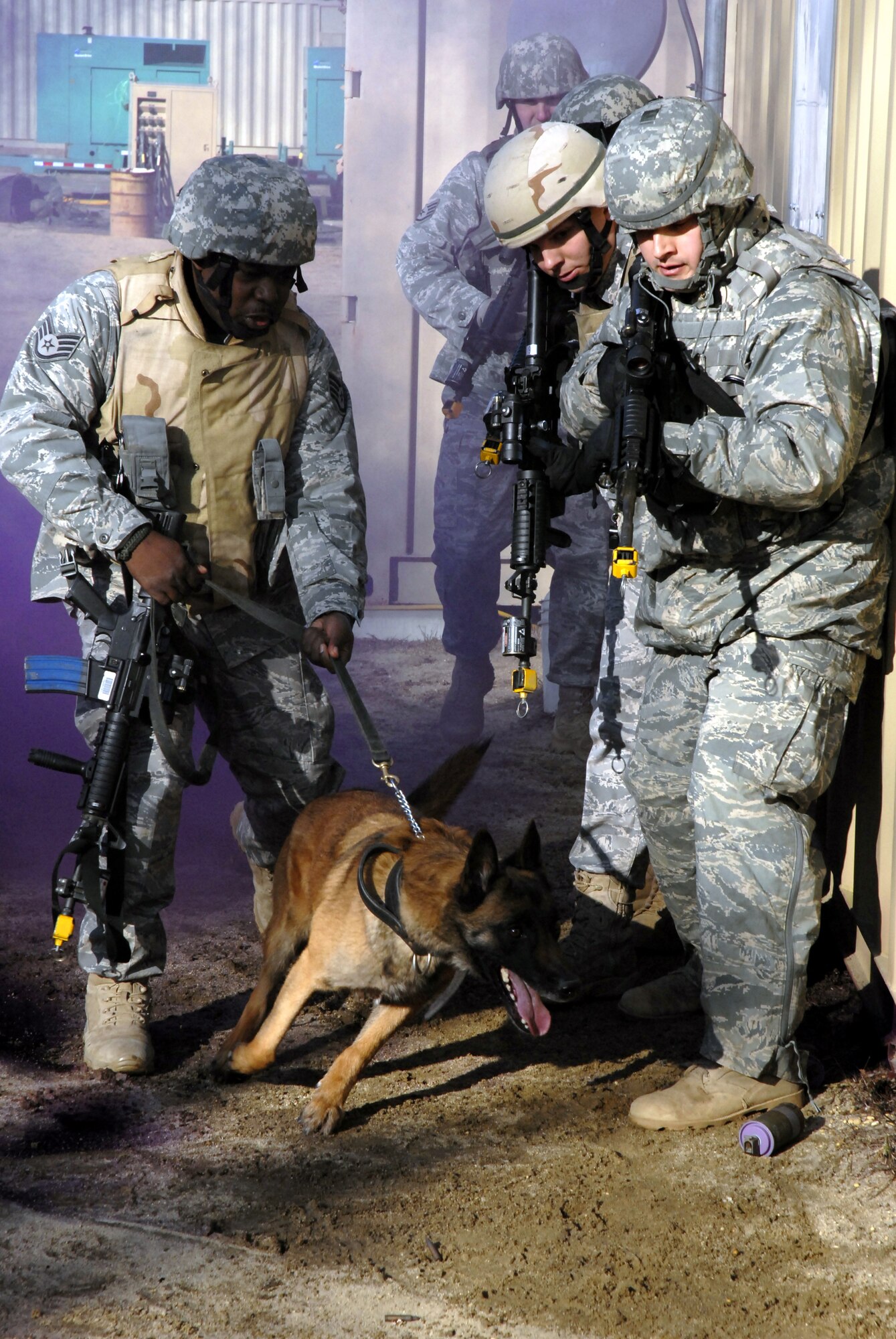 Staff Sgt. Jared Johnson and his military working dog Tino, both from the 43rd Security Forces Squadron at Pope Air Force Base, N.C., lead a team of students in the Air Force Phoenix Warrior Training Course into a building for a scenario in military operations in urban terrain training Feb. 23, 2009, on a range on Naval Air Engineering Station Lakehurst, N.J.  Phoenix Warrior is taught by the U.S. Air Force Expeditionary Center's 421st Combat Training Squadron and prepares security forces Airmen for upcoming deployments. (U.S. Air Force Photo/Staff Sgt. Paul R. Evans)