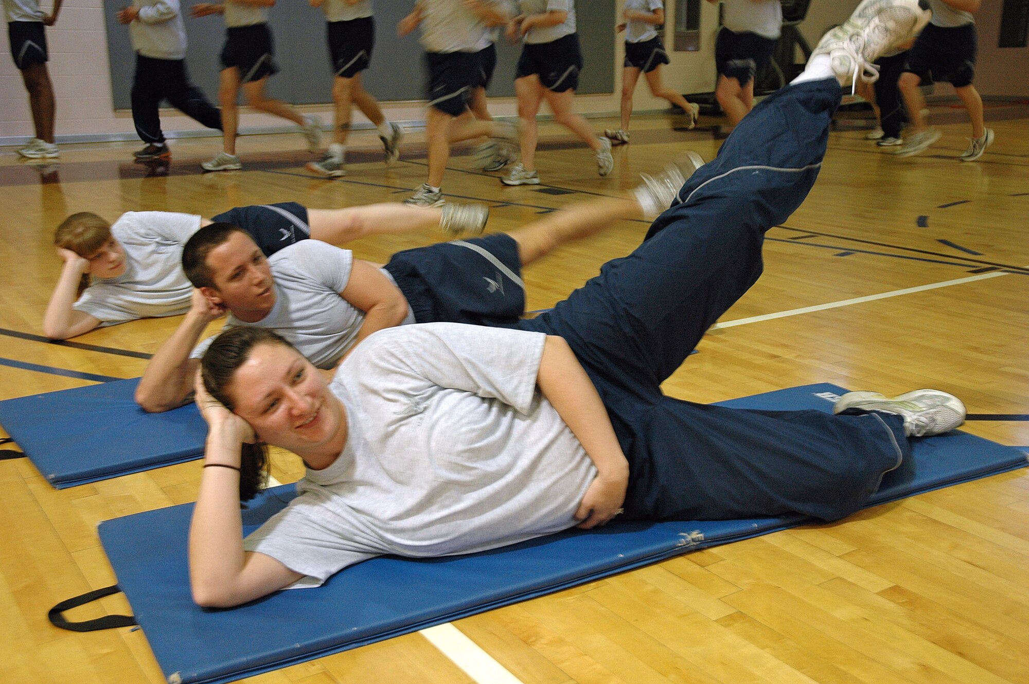 Tech. Sgt. Shannon Alequin, 21st Medical Support Squadron, and Airman 1st Class Casey Fletcher, 21st Dental Squadron, do leg raises as part of their participation in wing War Fit. The monthly program is one of the many venues the 21st Space Wing uses to encourage Airmen to always be ready to fight. 