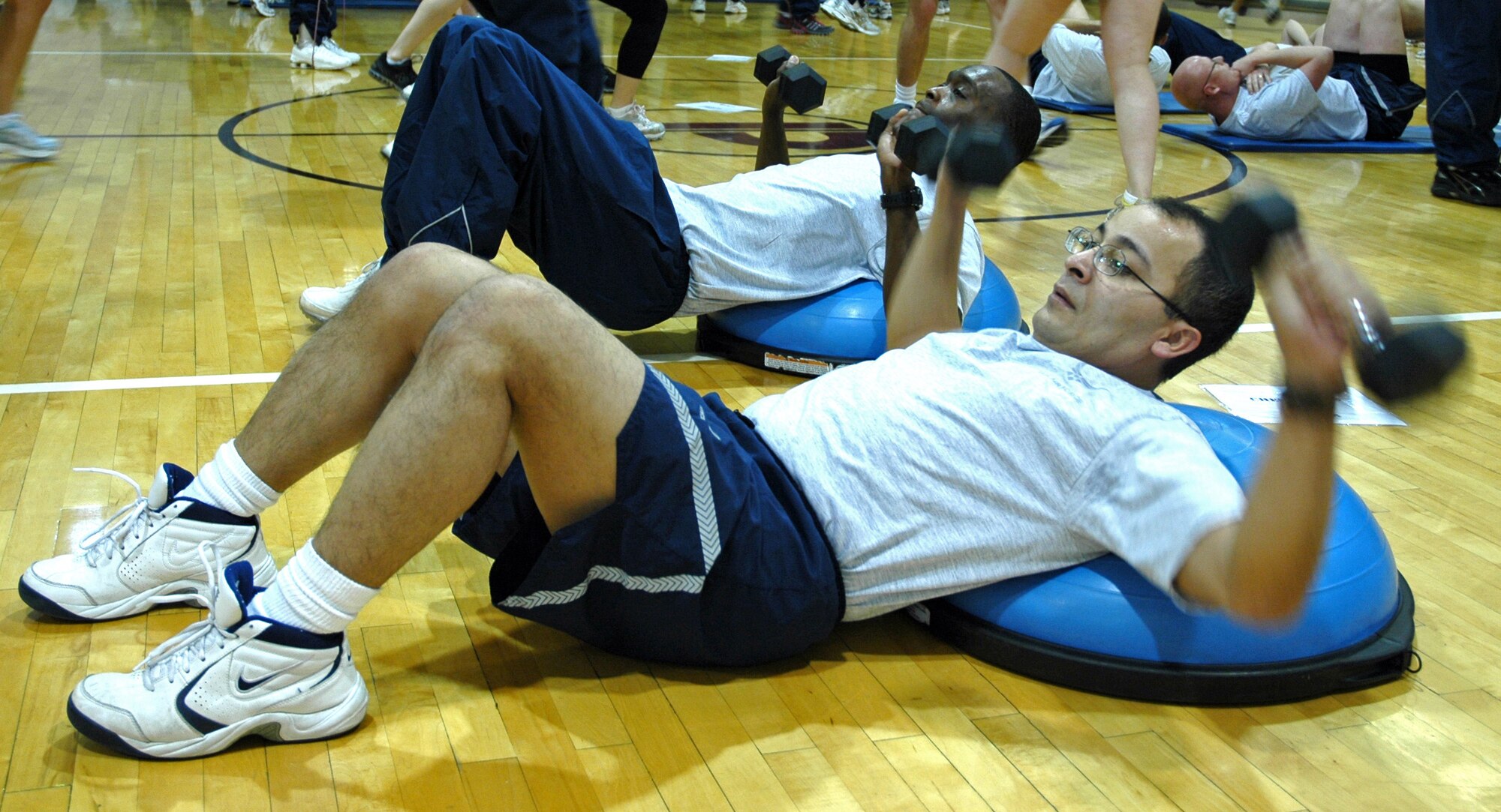 Tech. Sgt. Juan Ochoa, 21st Medical Support Squadron, and 2nd Lt. Rickey Anderson, 21st Communications Sq. (background) do chest press exercises on Bosu Balls. This equipment challenges core muscles and balance while people perform a variety of exercises; it is a great tool for maintaining a fit-to-fight lifestyle.  Wing War Fit is one way the 21st Space Wing showcases one aspect of the mission:  Developing and deploying Warrior Airmen to defend America and our Allies.