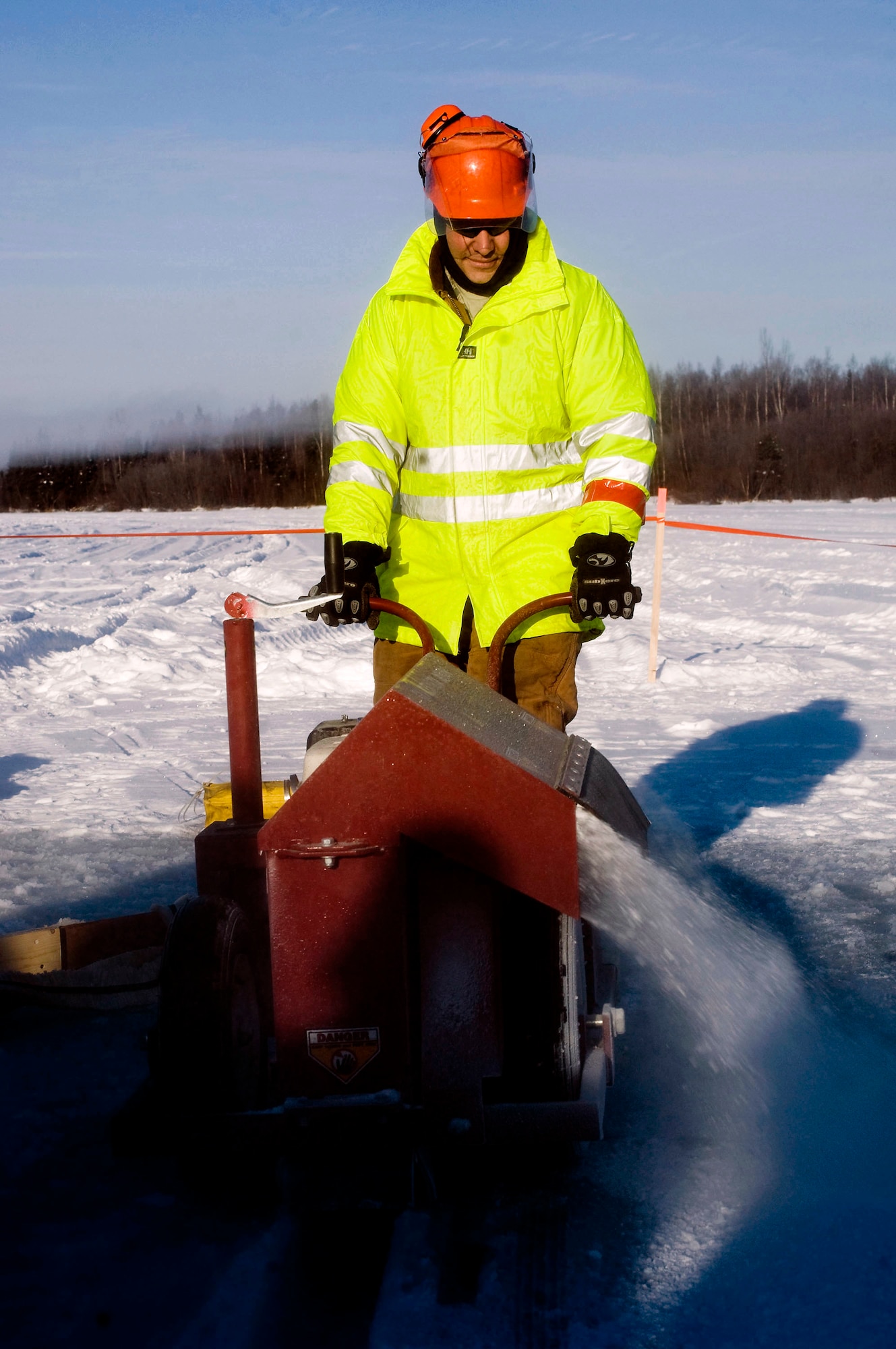 Tech. Sgt. James Crosley cuts a trench from the ice Feb. 24 on Six-mile Lake at Elmendorf Air Force Base, Alaska. The trench is used to collect oil using a mop rope. Sergeant Crosley is from the 611th Civil Engineer Squadron. (U.S. Air Force photo/Senior Airman Jonathan Steffen) 