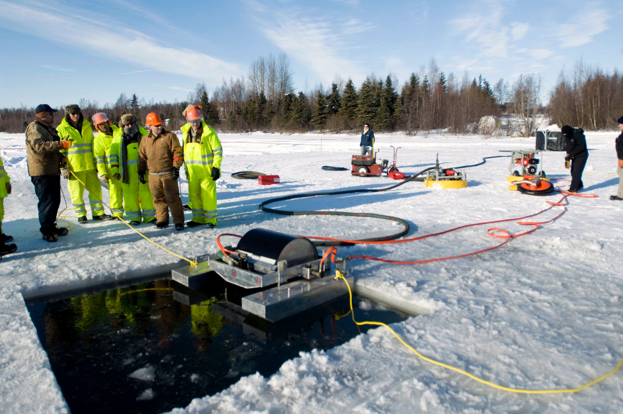 Airmen from the 611th Civil Engineer Squadron run the drum skimmer to collect oil on Six-mile Lake on Elmendorf Air Force Base, Alaska. (U.S. Air Force photo/Senior Airman Jonathan Steffen) 