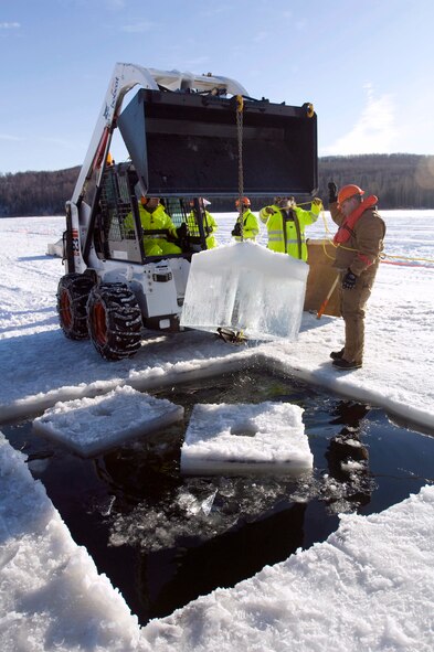 Senior Airman Jacob Smith yanks out a block of ice Feb. 24 on Six-mile Lake on Elmendorf Air Force Base, Alaska. The hole allows the oil to seep to top for collection. Airman Smith is from 611th Civil Engineer Squadron. (U.S. Air Force photo/Senior Airman Jonathan Steffen)