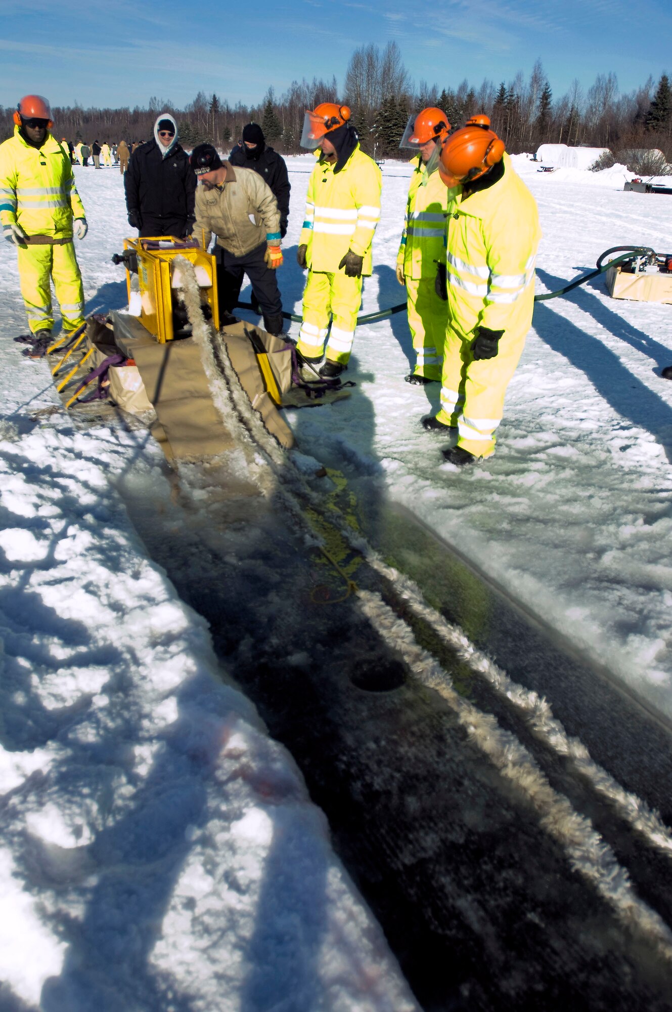 Airmen from the 611th Civil Engineer Squadron run the mop rope to practice collecting oil Feb. 24 on Elmendorf Air Force Base, Alaska. The mop rope is one of the techniques used for collecting oil. (U.S. Air Force photo/Senior Airman Jonathan Steffen)