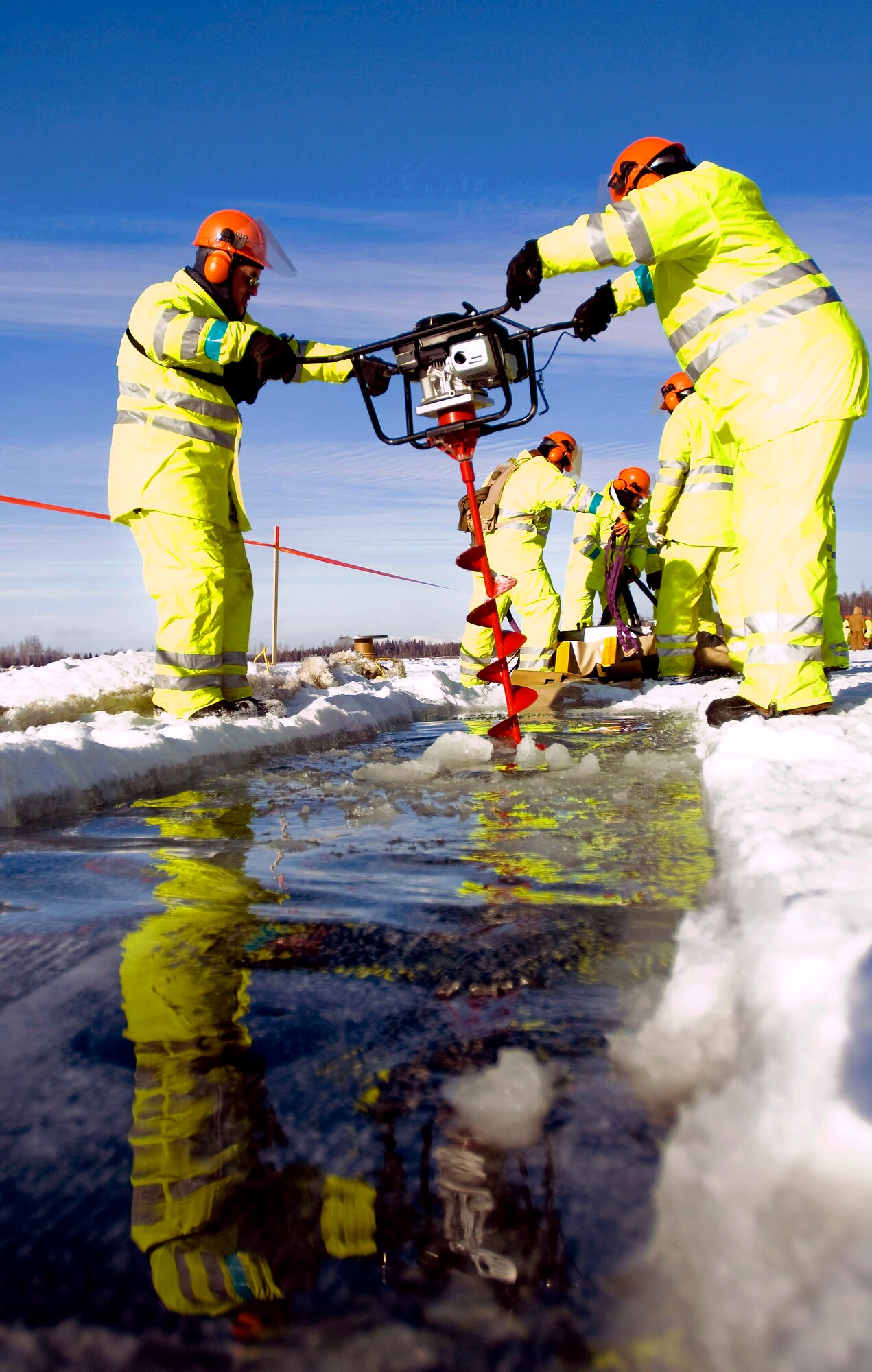 Master Sgt. James Fraser and Tech. Sgt. Eddie Campbell drill a hole in the ice using an auger Feb. 24. They were out on Six-mile Lake to practice oil spill recovery tactics on Elmendorf Air Force Base, Alaska. Sergeants Fraser and Campbell are with the 611th Civil Engineer Squadron. (U.S. Air Force photo/Senior Airman Jonathan Steffen) 
