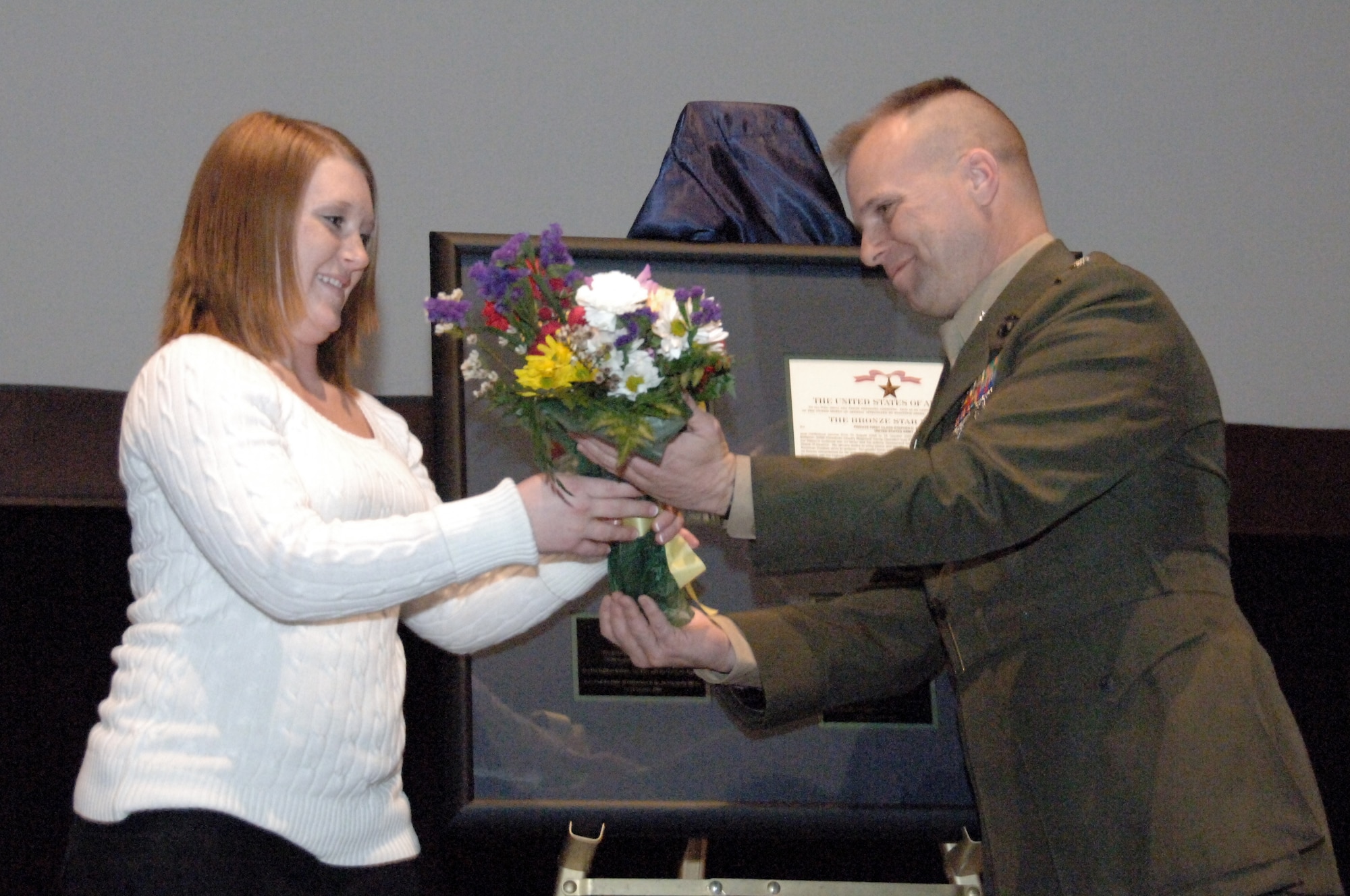 Army Lt. Col. Eric Garretty, the Montgomery Military Entrance Processing Station commander, presents flowers to Miranda Bicknell, widow of Pfc. Stephen Bicknell, during a ceremony at the Senior Non-Commissioned Officer Academy here Feb. 20. A native of Prattville, Ala., Private Bicknell died while serving in Iraq in October 2006. (Air Force photo by Donna Burnett)