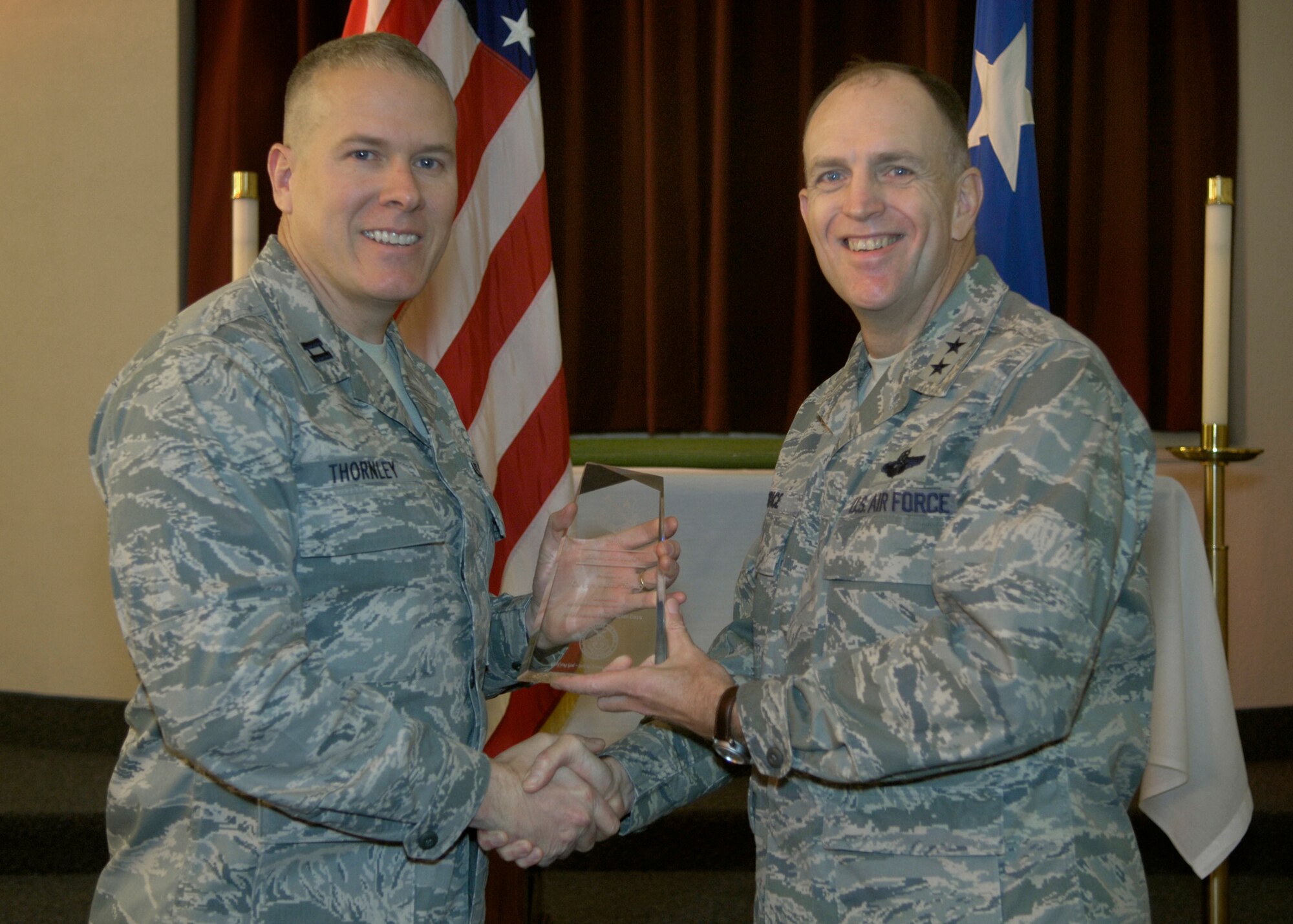 Maj. Gen. Ralph Jodice, Air Force District of Washington commander, presents the AFDW Oustanding Chaplain Corps Company Grade Officer of the Year Award to Chaplain (Capt.) Andrew Thornley. The award presentation took place Feb. 25, 2009, at the Andrews Air Force Base, Md., chapel.  (U.S Air Force photo by Senior Airman Renae Kleckner.)