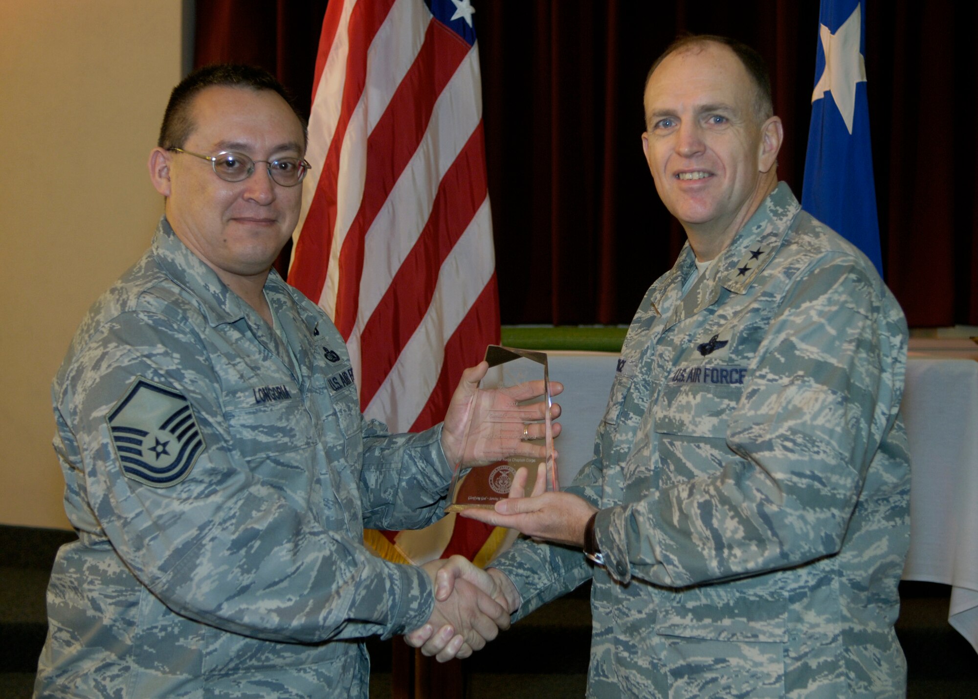 Maj. Gen. Ralph Jodice, Air Force District of Washington commander, presents the AFDW Oustanding Chaplain Corps Senior NCO of the Year Award to Master Sgt. Christopher Longoria. The award presentation took place Feb. 25, 2009, at the Andrews Air Force Base, Md., chapel.  (U.S Air Force photo by Senior Airman Renae Kleckner.)
