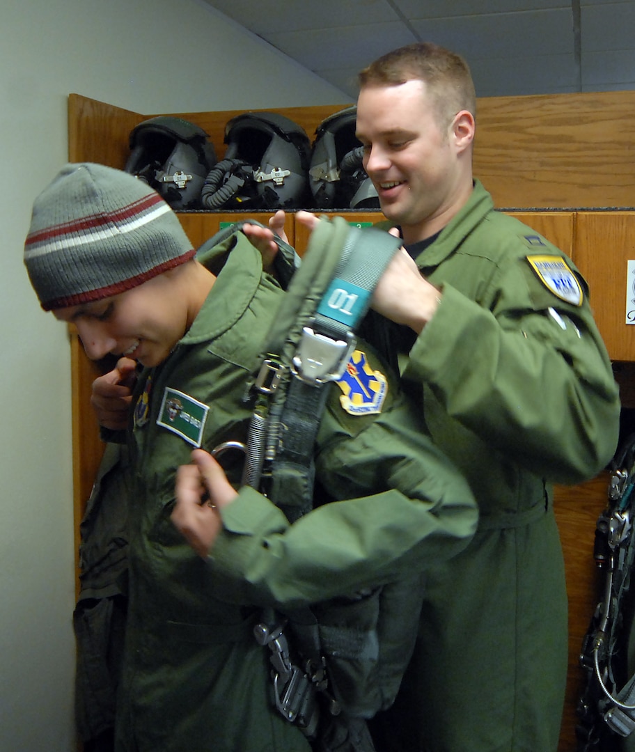 Capt. Ryan Venhuizen, a 560th Flying Training Squadron instructor pilot, helps 13-year-old Jared Garza try on a parachute during Pilot for a Day on Feb. 27. (U.S. Air Force photo by Steve White)