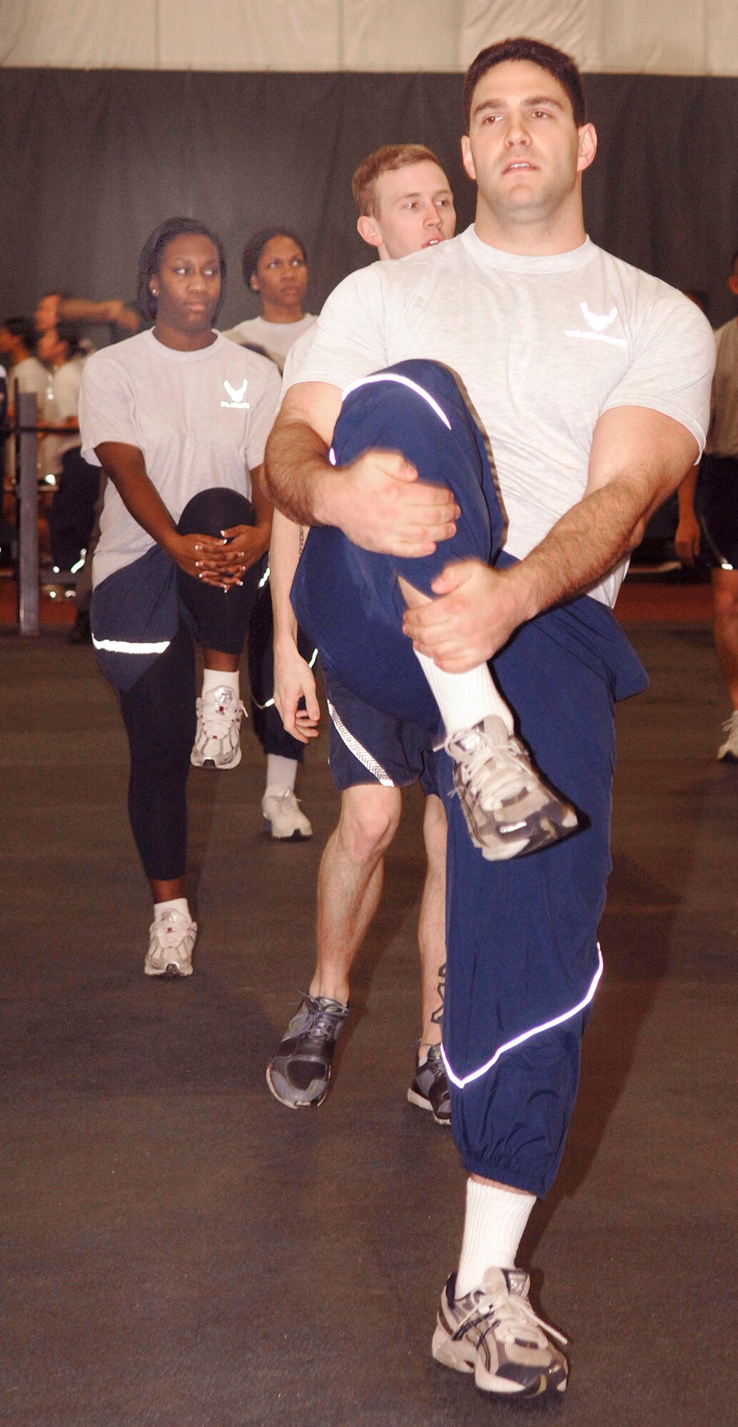 Captain Joshua Cherinski, 316 CPTS budget officer, performs knee lifts as a warm up exercise with other members of his unit Feb 18. The Tactical Fitness Center allows base personnel to implement new workout routines for physical fitness training. (US Air Force photo by Bobby Jones)