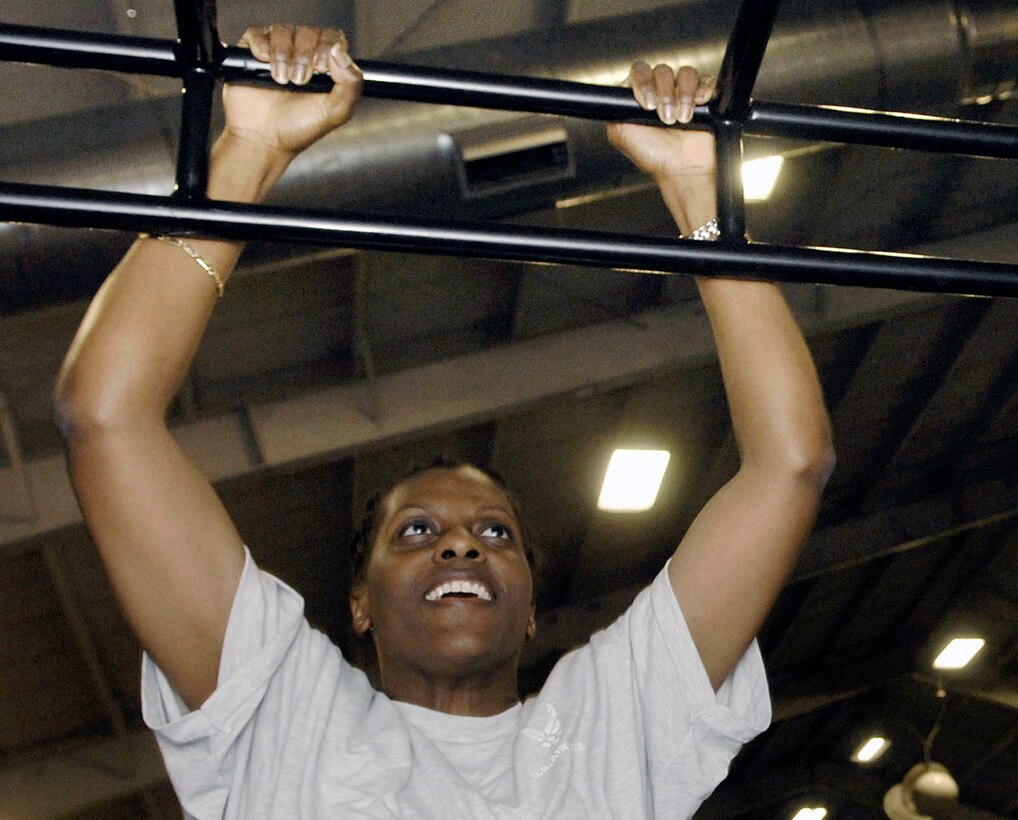 Master Sgt. Janice Sears, 316th Comptroller Squadron NCO in charge of special actions, performs pull-ups during a fitness class Feb 18. The class, offered at the West Fitness Center, provides a variety of exercises to include lunges, running, and weight lifting. (US Air Force photo by Bobby Jones)