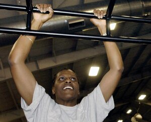 Master Sgt. Janice Sears, 316th Comptroller Squadron NCO in charge of special actions, performs pull-ups during a fitness class Feb 18. The class, offered at the West Fitness Center, provides a variety of exercises to include lunges, running, and weight lifting. (US Air Force photo by Bobby Jones)