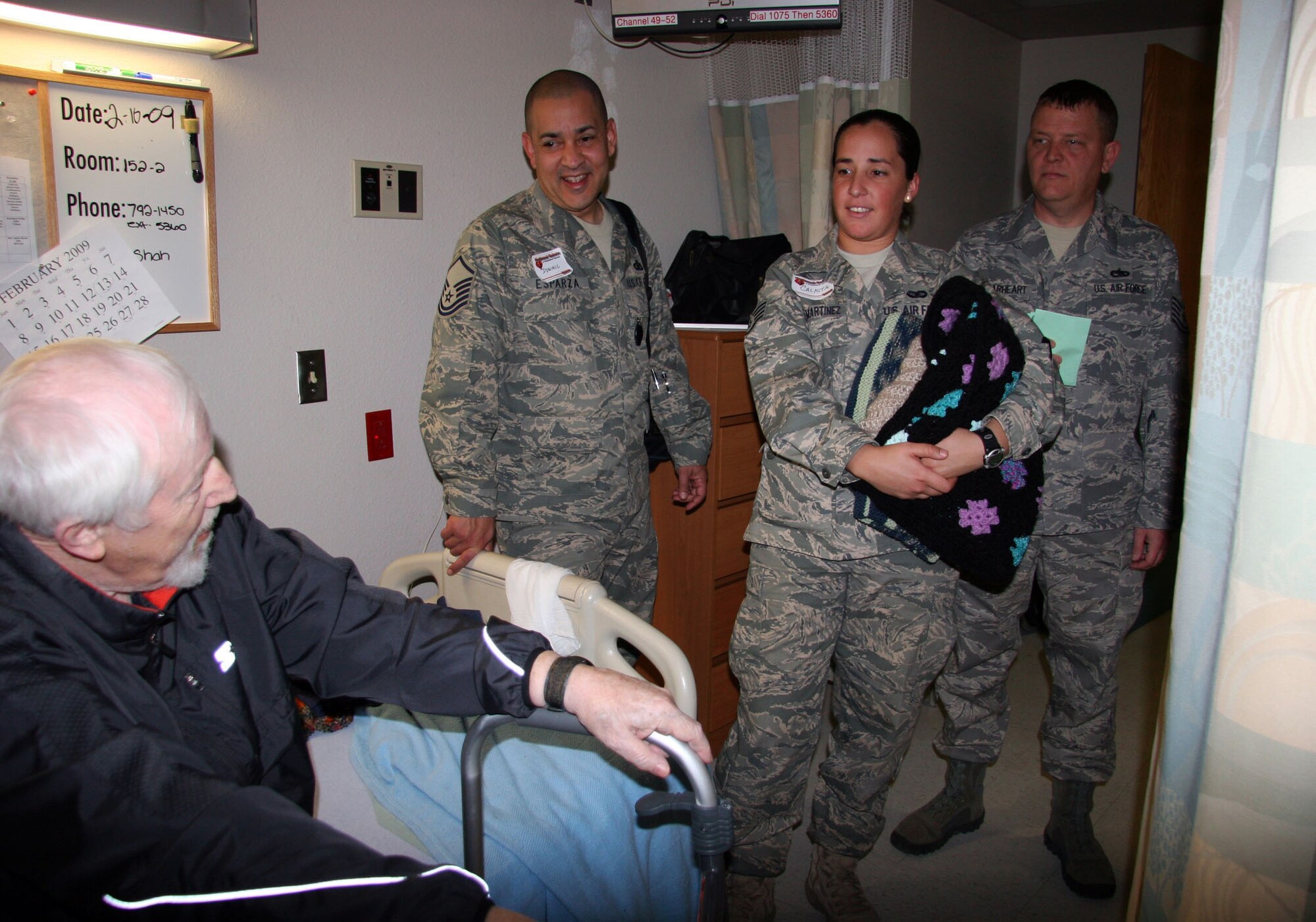 TUCSON, Ariz. -- Air Force Reservists from the 943rd Rescue Group, Davis-Monthan AFB, Ariz. visited with Mr. Kim Gillett, U.S. Army veteran, in his hospital room at the Southern Arizona VA Health Care System, Tucson, Ariz., Feb. 11, 2009 during the National Salute to Hospitalized Veterans Celebration.  They shared a common bond as the Rescue Group uses HH-60 helicopters to conduct combat search and rescue made by Sikorski and Mr. Gillet worked as an engineer on the Sikorski, Piasecki, and other helicopters.  He shared his experiences working with the helicopters and the characters he met along the way in the early days of helicopter aviation. (U.S. Air Force Photo/Master Sgt. Ruby Zarzyczny)