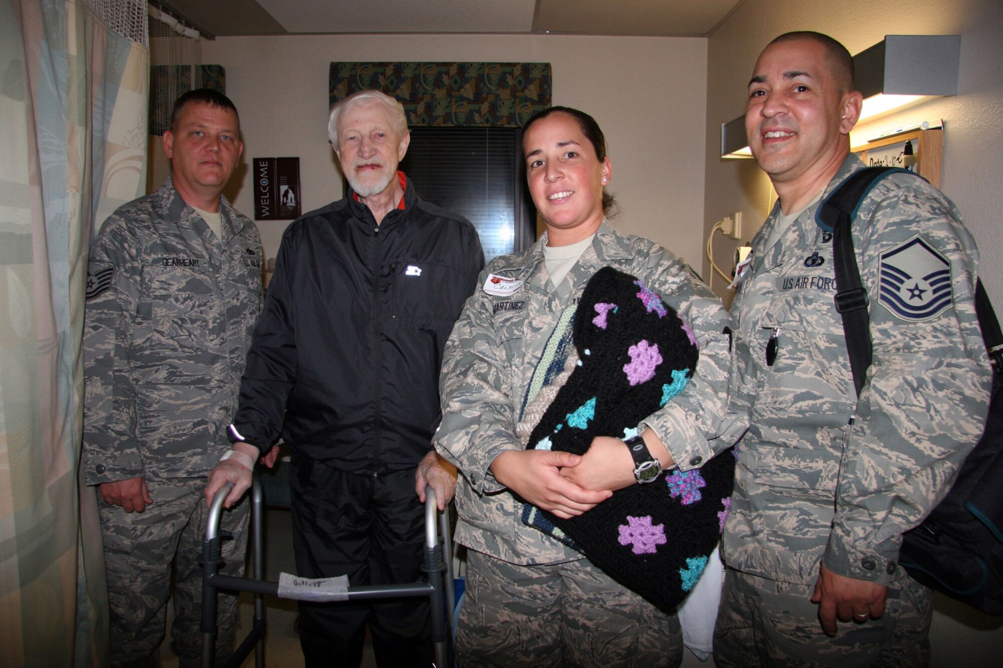 TUCSON, Ariz. -- Tech. Sgt. Lacy Gearheart, Mr. Kim Gillett, U.S. Army Veteran, Staff Sgt. Calista Heath-Martinez and Master Sgt. Dominic Esparza pose for a picture after visiting with Mr. Gillett in his hospital room during the National Salute to Hospitalized Veterans Celebration at the Southern Arizona VA Health Care System, Feb. 11, 2009. (U.S. Air Force Photo/MSgt Ruby Zarzyczny) 