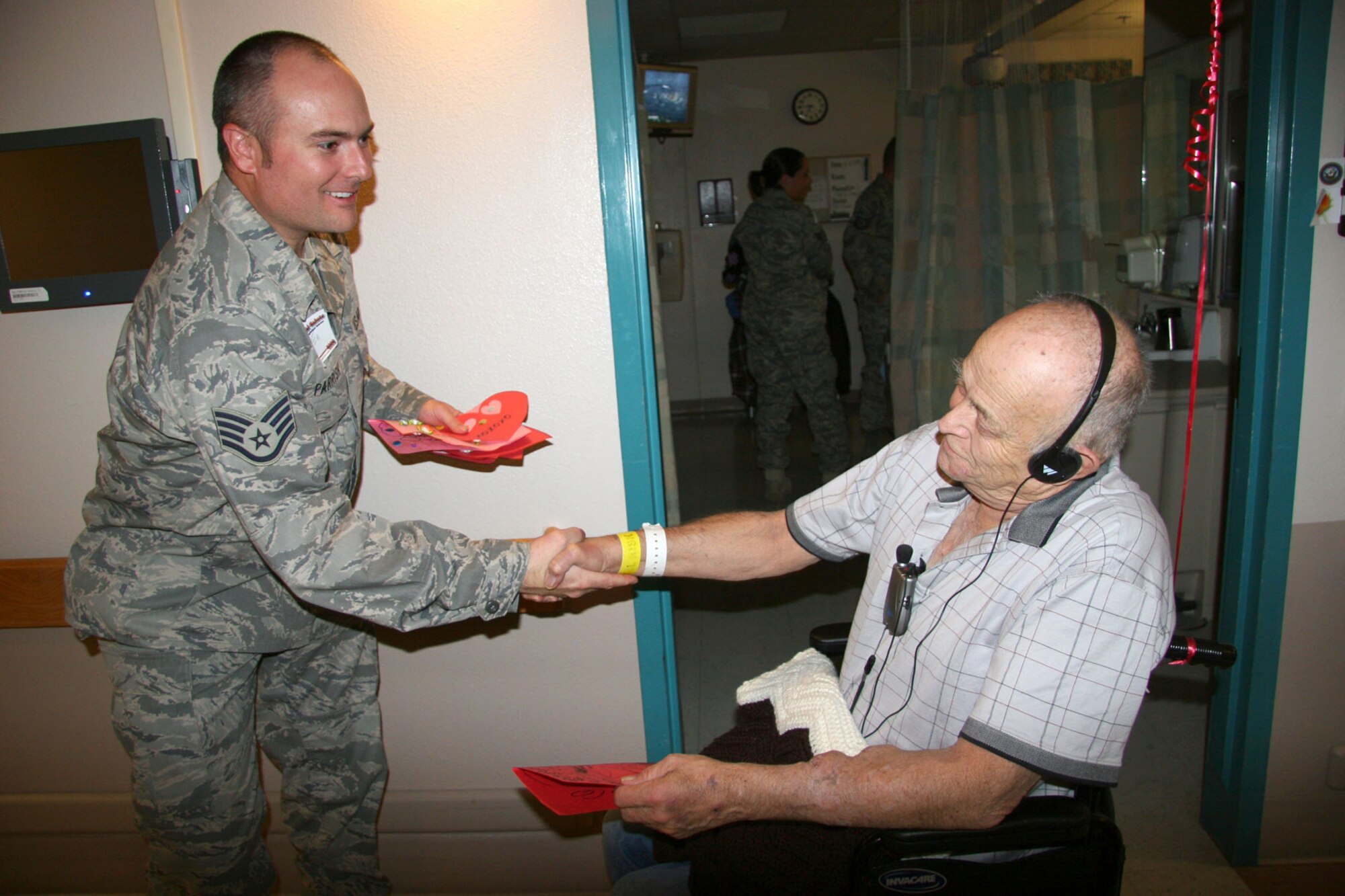 TUCSON, Ariz. -- Staff Sgt. Tim Parrish, 943rd Maintenance Squadron, Davis-Monthan AFB, Ariz., shakes hands with Mr. Roy Ivans, U.S. Navy veteran, after thanking him for his service during the National Salute to Hospitalized Veterans Celebration at the Southern Arizona VA Health Care System, Tucson, Ariz., Feb. 11, 2009. He and 11 other Air Force Reservists and their families from the 943rd Rescue Group visited with the veterans during this celebration.  Everyone handed out valentines, made by local school children, and blankets, made by VA volunteers, to the veteran patients. They thanked them for their service and exchanged stories while sharing the precious gift of time. (U.S. Air Force Photo/MSgt Ruby Zarzcyzny)
