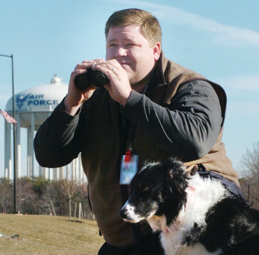 Dan Vredenburgh, BASH Program manager, and Bree, survey a man-made pond for geese near the Main Gate at Andrews Feb. 20 (US Air Force photo by Bobby Jones)