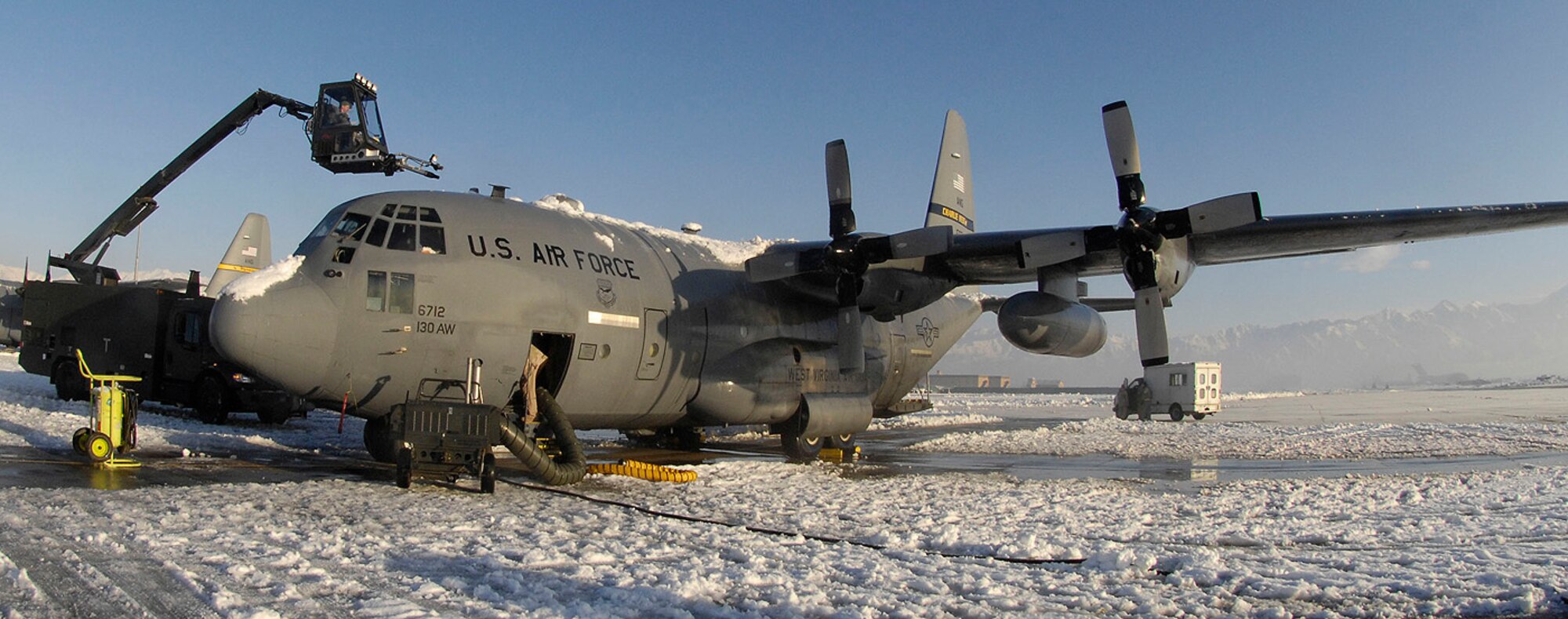 Tech Sgt. David Anderson, 774th Expeditionary Airlift Squadron crew chief, de-ices a C-130H Hercules at Bagram Air Field, Afghanistan, Feb.14.  Sergeant Anderson is deployed from West Virginia Air National Guard's 130th Airlift Squadron to support Operation Enduring Freedom.  Bagram received six inches of snow overnight, the most accumulation in a 24-hour period in the month of February since the base opened in 2001. (U.S. Air Force photo by Maj. Carie A. Parker) 