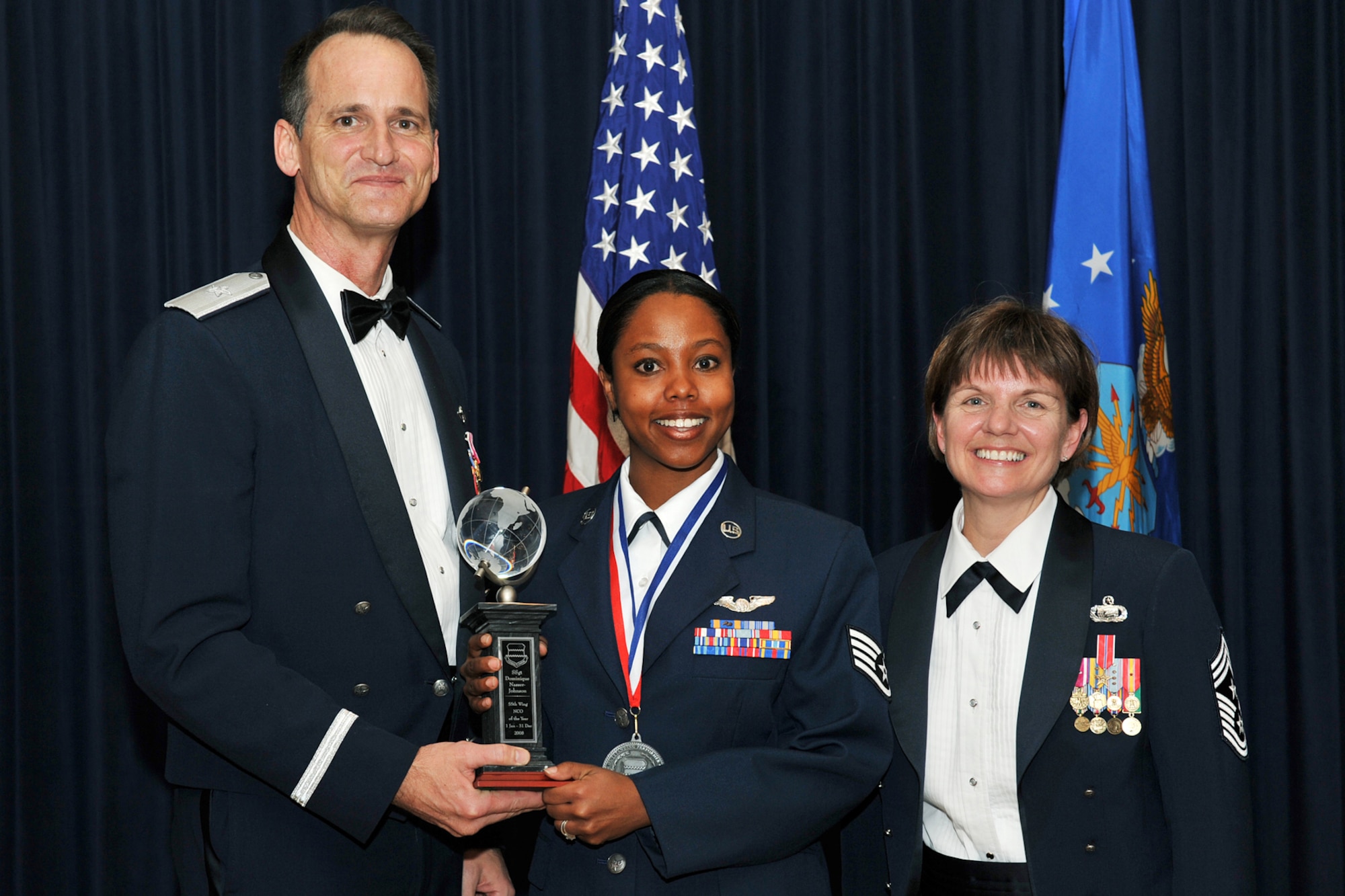 OFFUTT AIR FORCE BASE, Neb. -- Brig. Gen. James Jones, 55th Wing commander, and Chief Master Sgt. Lisa Sirois, 55th Wing command chief, congratulate Staff Sgt. Dominque Nasser-Johnson, 55th Electric Combat Group, for winning the Non-commissioned Officer of the Year during the Annual Awards Banquet held at the Patriot Club Feb. 27. Members of the 55th Wing came together to honor those who have demonstrated tireless dedication, faithful service and excelled in the past year representing the best of the best according to the general.