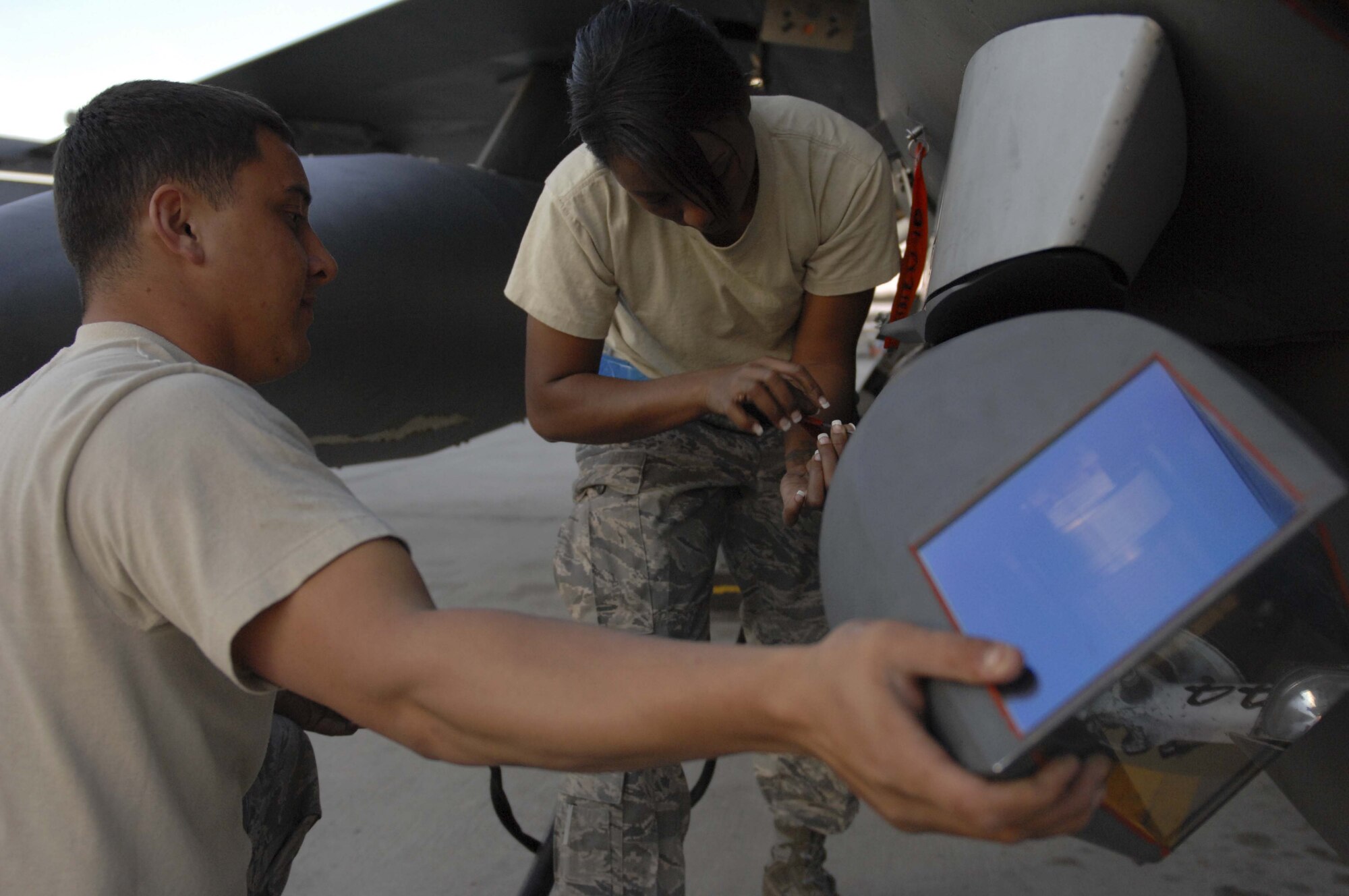 NELLIS AIR FORCE BASE, Nev. -- Senior Airman Alden Gehrt (left), an F-16 Fighting Falcon avionics apprentice, and Staff Sgt. Tarha Mazyck, an avionics craftsman, tighten screws on a sniper pod before night flying operations during Red Flag 09-3 at Nellis Air Force Base, Nev., Feb. 26, 2009. Red Flag is a multi-national exercise providing a realistic environment to practice combat scenarios. Both Airman Gehrt and Sergeant Mazyck are deployed here from the 52nd Aircraft Maintenance Squadron at Spangdahlem Air Base, Germany. (U.S. Air Force Photo by Senior Airman Larry E. Reid Jr.)