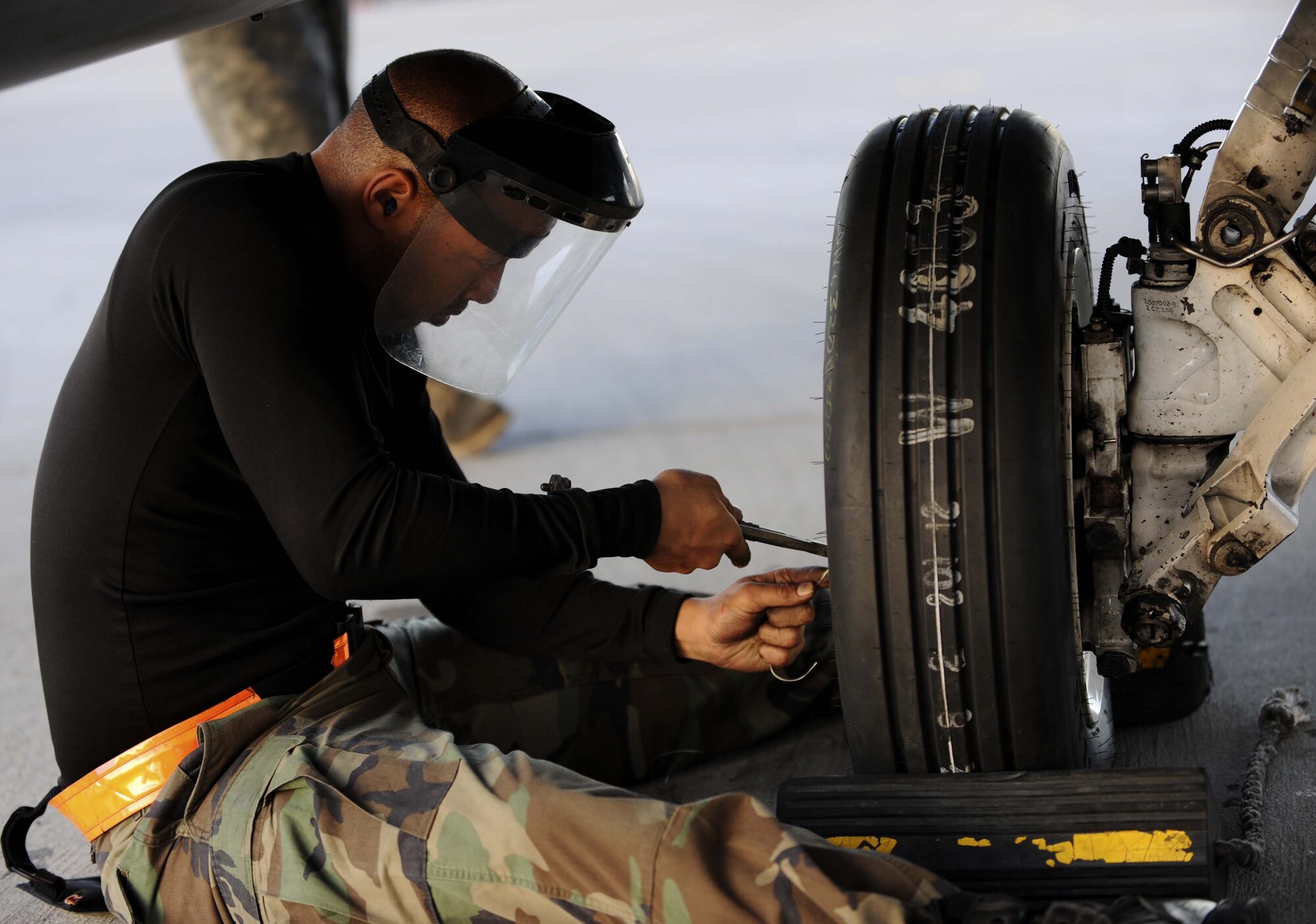 NELLIS AIR FORCE BASE, Nev. -- Staff Sgt. Sydney Chapman, 52nd Aircraft Maintenance Squadron F-16 Fighting Falcon crew chief, tightens safety wires on the aircraft's hubcap before night flying operations during Red Flag 09-3 at Nellis Air Force Base, Nev., Feb. 26, 2009. Red Flag is a multi-national exercise providing a realistic environment to practice combat scenarios. Sergeant Chapman is deployed here from the 52nd Aircraft Maintenance Squadron at Spangdahlem Air Base, Germany. (U.S. Air Force Photo by Senior Airman Larry E. Reid Jr.)