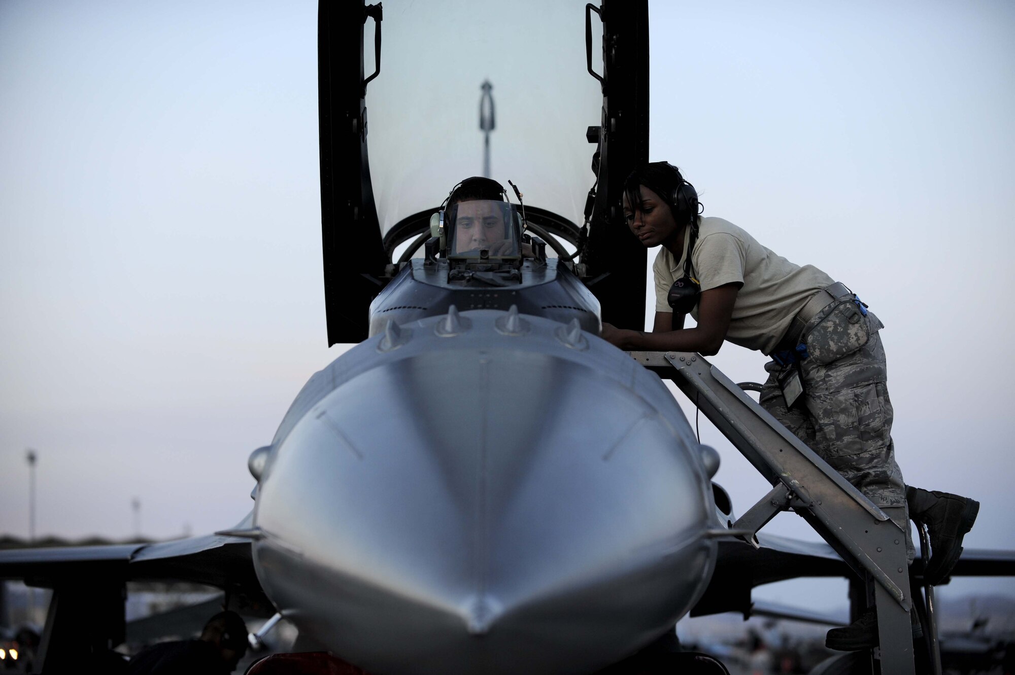 NELLIS AIR FORCE BASE, Nev. -- Senior Airman Alden Gehrt (cockpit), an F-16 Fighting Falcon avionics apprentice, and Staff Sgt. Tarha Mazyck, an avionics craftsman, conduct routine system maintenance before night flying operations during Red Flag 09-3 at Nellis Air Force Base, Nev., Feb. 26, 2009. Red Flag is a multi-national exercise providing a realistic environment to practice combat scenarios. Both Airman Gehrt and Sergeant Mazyck are deployed here from the 52nd Aircraft Maintenance Squadron at Spangdahlem Air Base, Germany. (U.S. Air Force Photo by Senior Airman Larry E. Reid Jr.)