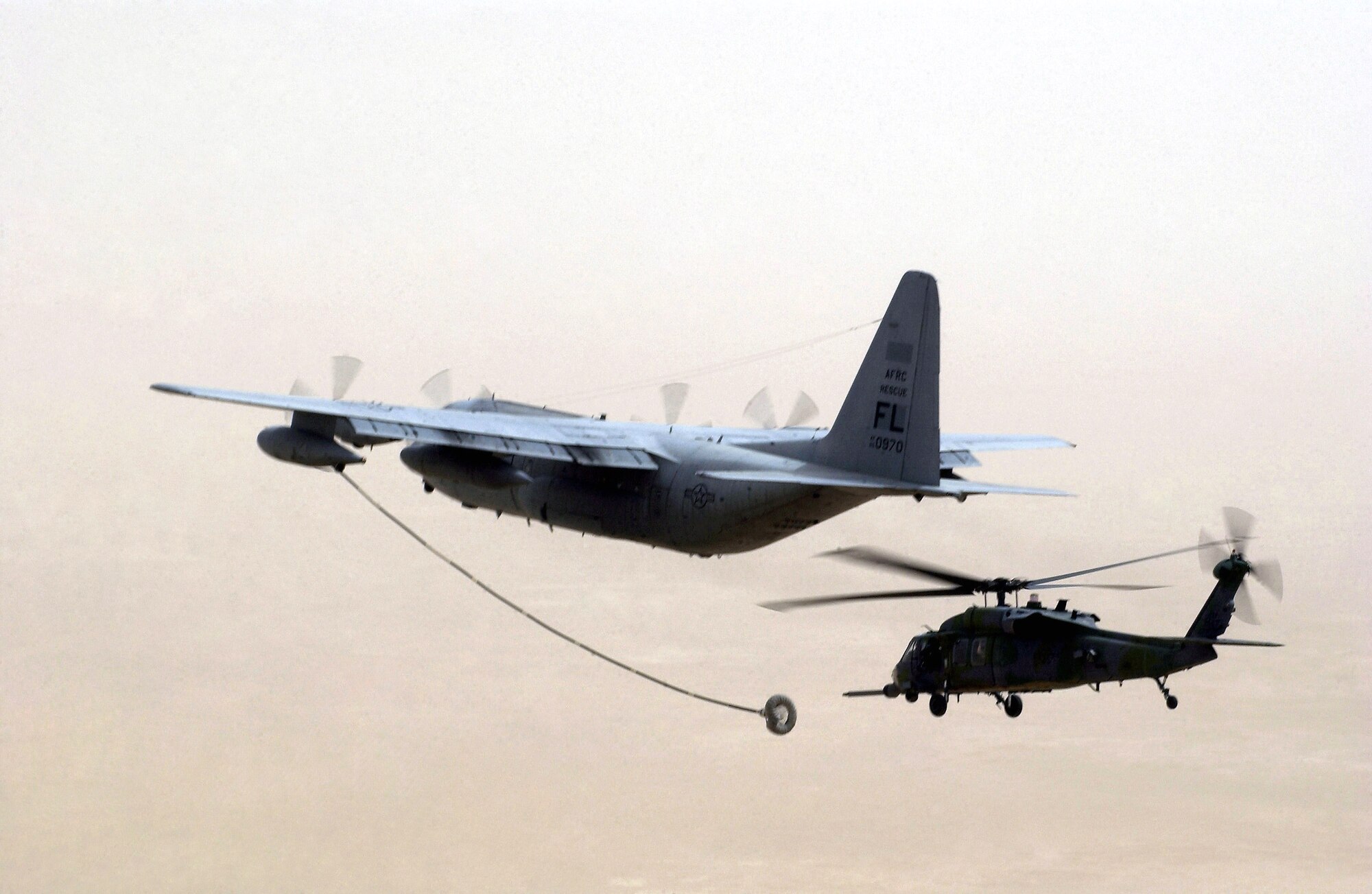 An HH-60G Pave Hawk helicopter approaches the refueling drogue of an HC-130P/N Hercules long-range refueling aircraft. Similar aircraft with 920th Rescue Wing rescue crews from Patrick Air Force Base, Fla., are joining in the search for two NFL players and one other boater missing in the Gulf of Mexico. (U.S. Air Force photo)
