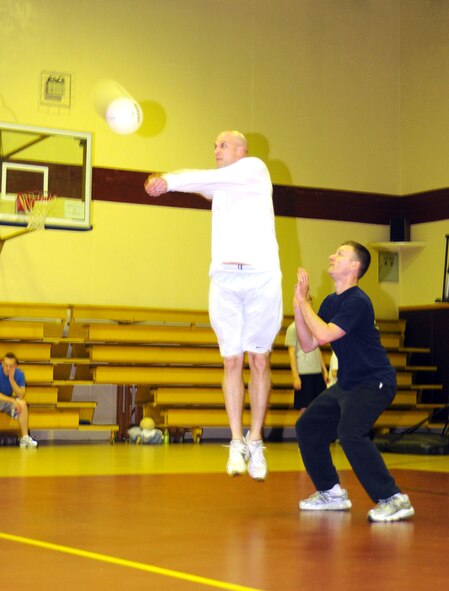 Jonathan Porter, Armed Forces Network team, jumps up to bump the ball during a late-night volleyball game, Feb. 27, at the Incirlik Fitness Center. Team Tamum Monkey Bunch won with a score of 25-13. The game took place as an athletic alternative to other late-night weekend activities. (U.S. Air Force photo by Senior Airman Heather Stanton)