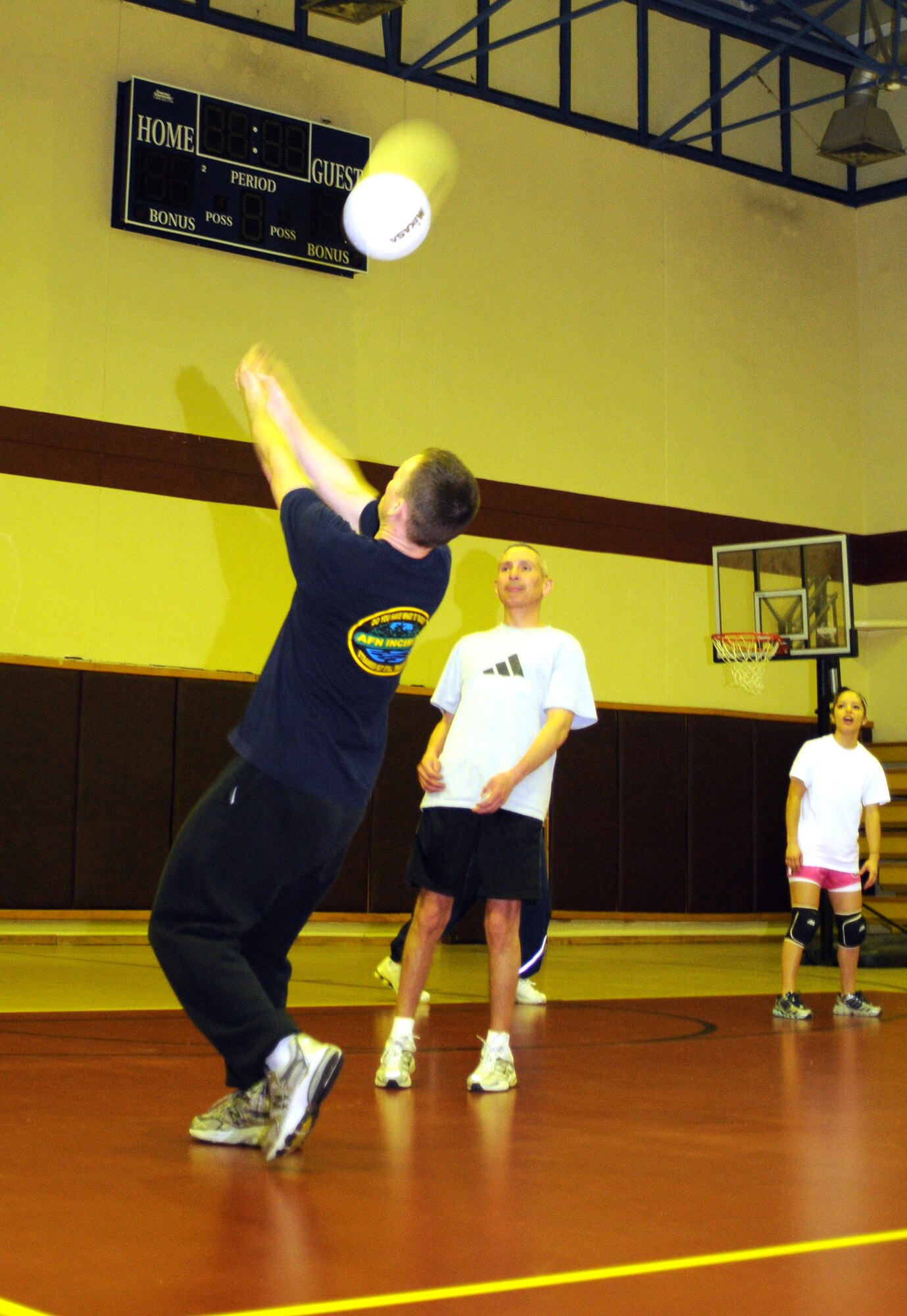 Glenn Smith, Armed Forces Network team, bumps the ball in reverse to get it over the net during a late-night volleyball game, Feb. 27, at the Incirlik Fitness Center. Team AFN lost to Team Tamum Monkey Bunch 25-13. The game took place as an athletic alternative to other late-night weekend activities. (U.S. Air Force photo by Senior Airman Heather Stanton)