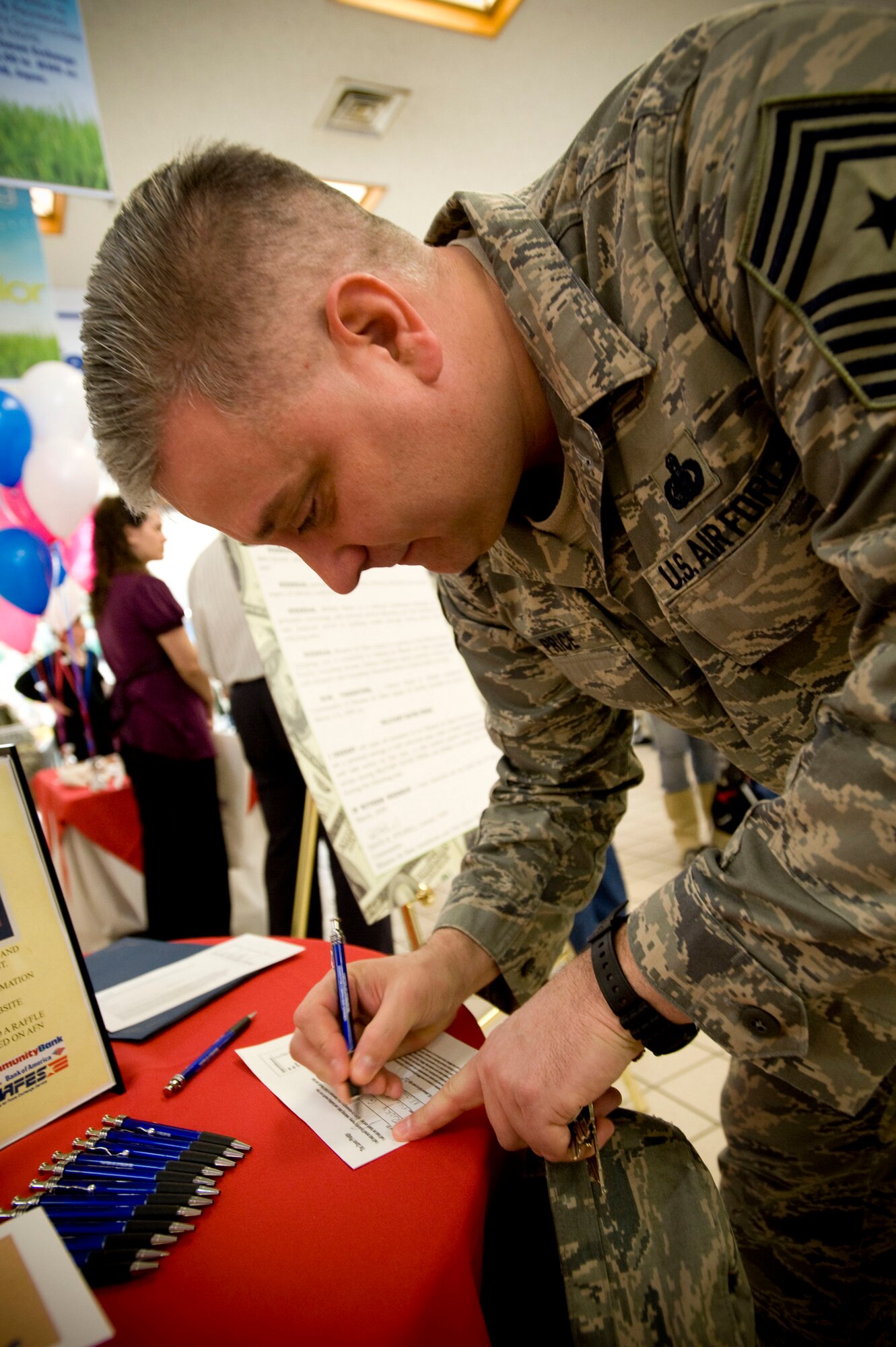 MISAWA AIR BASE, Japan -- Chief Master Sgt. Rick Price, 35th Fighter Wing command chief, signs a pledge March 2, 2009 to save. Chief Price was one of the many attendees who pledged to participate in Military Saves Week at Misawa Air Base.  (U.S. Air Force photo by Staff Sgt. Samuel Morse)