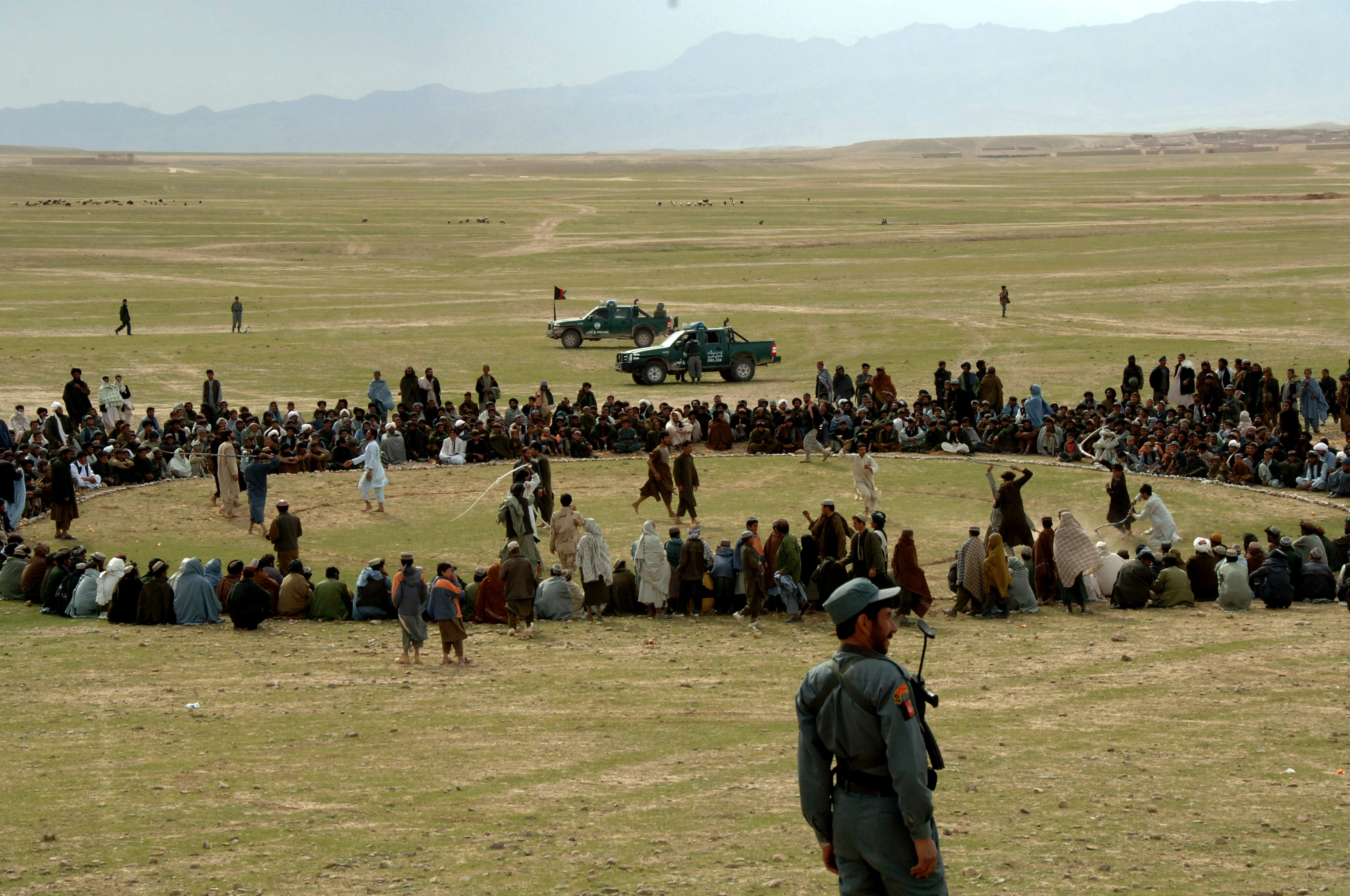 Two dorah teams battle it out while an Afghan police officer pulls