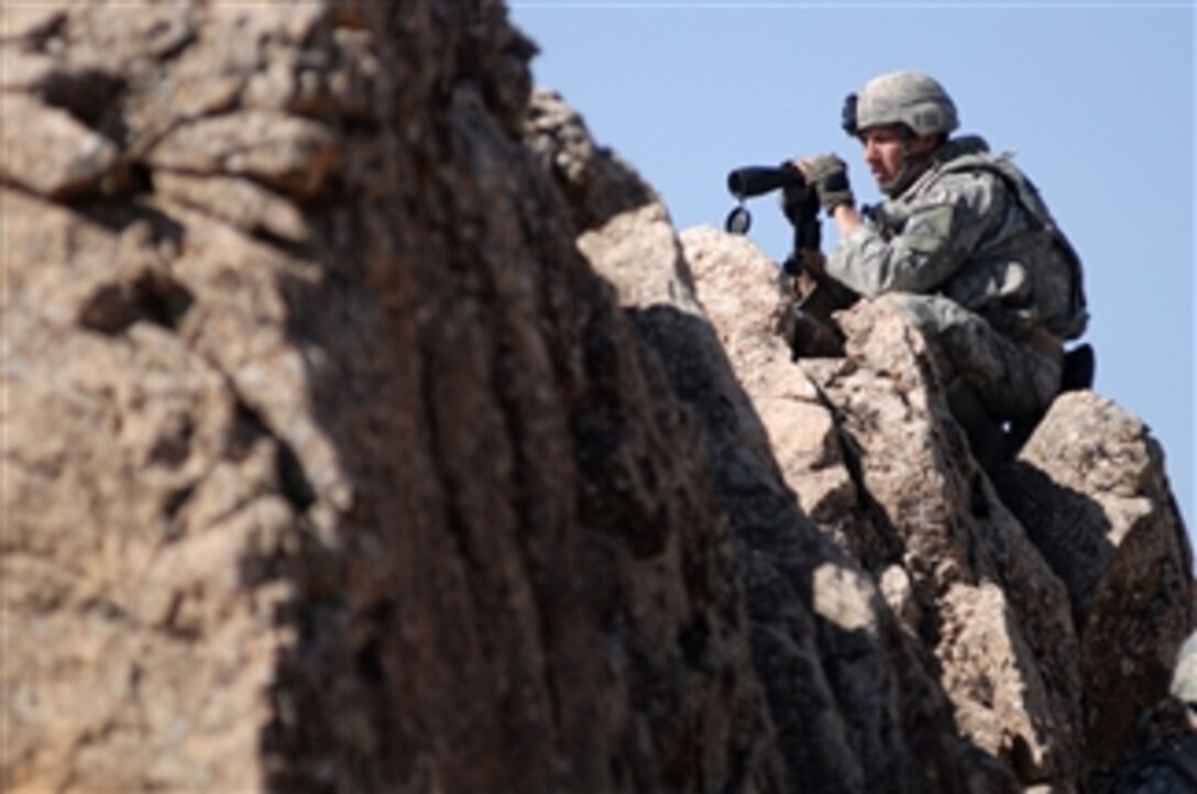 U.S. Army Spc. Jeffery Lewis from Bravo Company, 1st Battalion, 4th Infantry Regiment, U.S. Army Europe searches for signs of the enemy from the top of a ridge near Forward Operation Base Lane, Zabul Province, Afghanistan, on Feb. 26, 2009.  