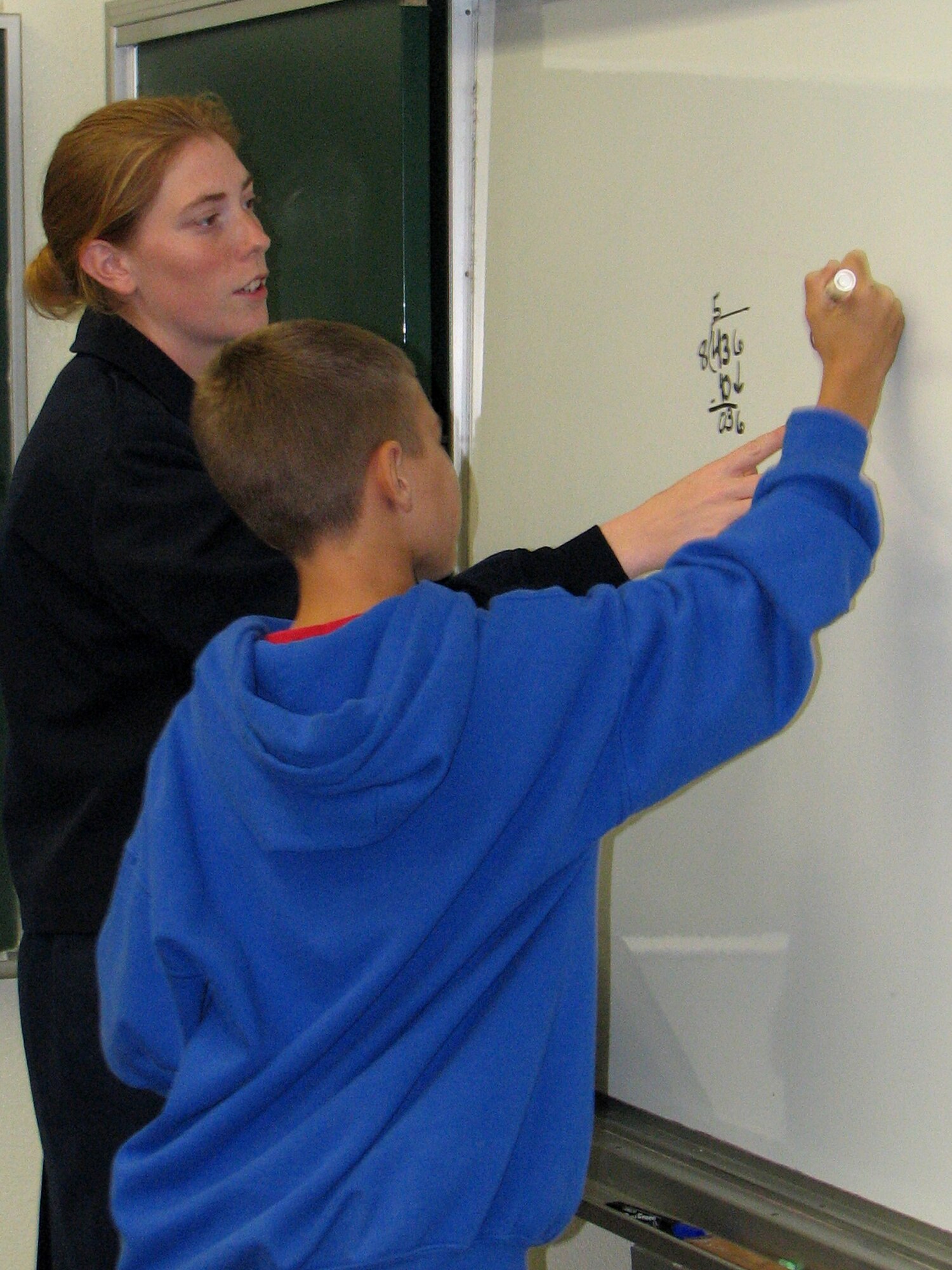 Staff Sgt. Rose Witmer, a 390th Intelligence Squadron cryptologic operator, helps Brendan McCafferty understand mathematics.  Team Kadena members mentor students to help them succeed academically. (Courtesy photo)