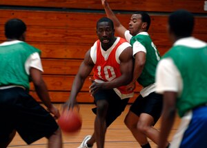 Michael McHoney dribbles  through defenders as he penetrates to the hoop during an intramural basketball game at the Fitness and Sports Center here
March 3. The Army National Guard team defeated the Logistics Readiness Squadron 45-37. McHoney is with the Army National Guard in Charleston, South Carolina. (U.S. Air Force photo/Senior Airman Timothy Taylor)