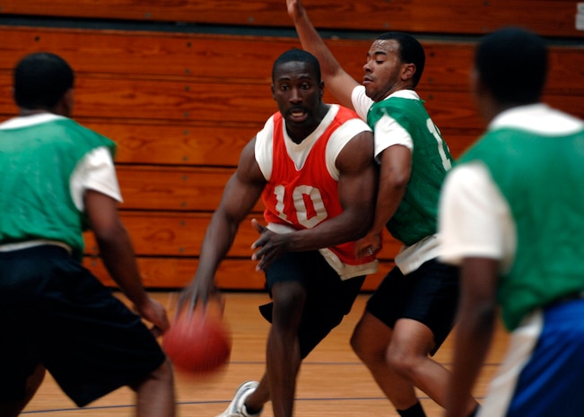 Michael McHoney dribbles  through defenders as he penetrates to the hoop during an intramural basketball game at the Fitness and Sports Center hereMarch 3. The Army National Guard team defeated the Logistics Readiness Squadron 45-37. McHoney is with the Army National Guard in Charleston, South Carolina. (U.S. Air Force photo/Senior Airman Timothy Taylor)