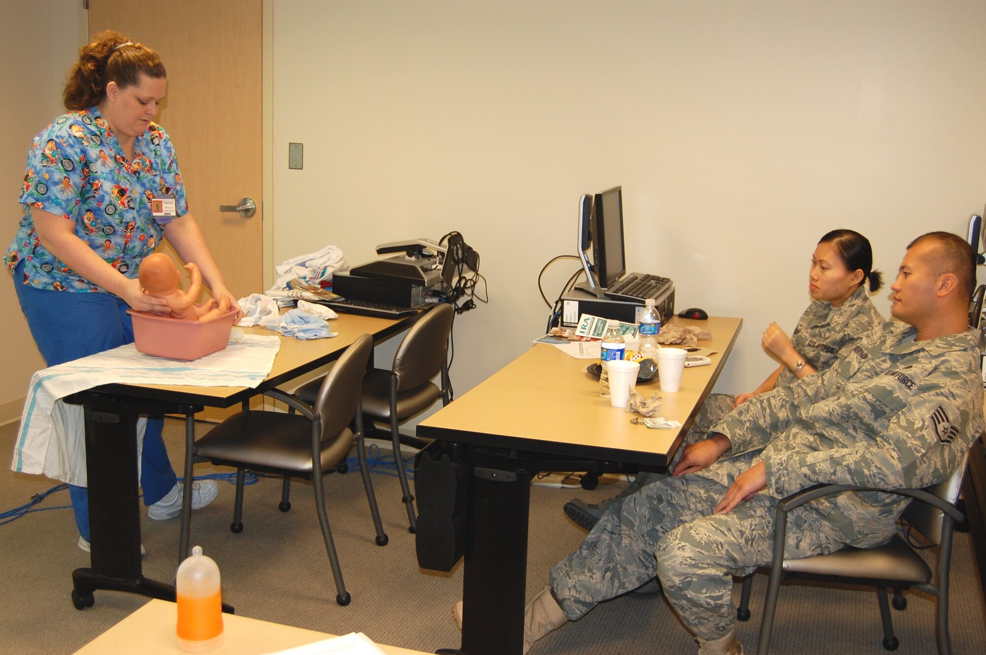 Andrea Schram, a medical technician in the 81st Medical Operations Squadron’s pediatric specialties, demonstrates the proper technique to bathe an infant during the Feb. 12 Baby Boot Camp.  Expectant parents Staff Sgts. Vongvaly Kohjararoentham, center, 81st Medical Support Squadron, and Kriangsak Kohjararoentham, 81st Force Support Squadron, joined several expecting and new parents for the class that covers common concerns of new parents such as colic, safety, immunizations, feeding issues, developmental milestones, booking appointments and infant dental care.  (U.S. Air Force photo by Steve Pivnick)