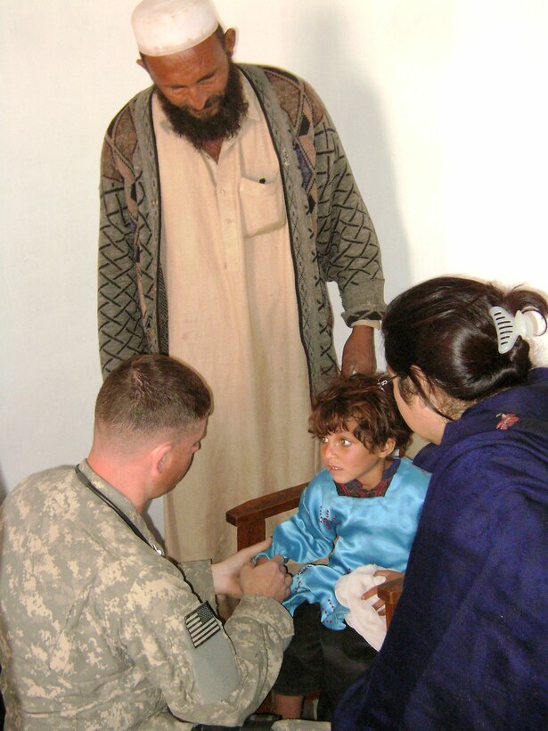 Technical Sgt. Kyle Baker examines an injured girl at the Hope of Mother Clinic Feb. 24 in the Surkh Rod District of Afghanistan. Sergeant Baker is a medic with the provincial reconstruction team in Afghanistan's Nangarhar province. (U.S. Air Force photo/Capt. Dustin Hart) 