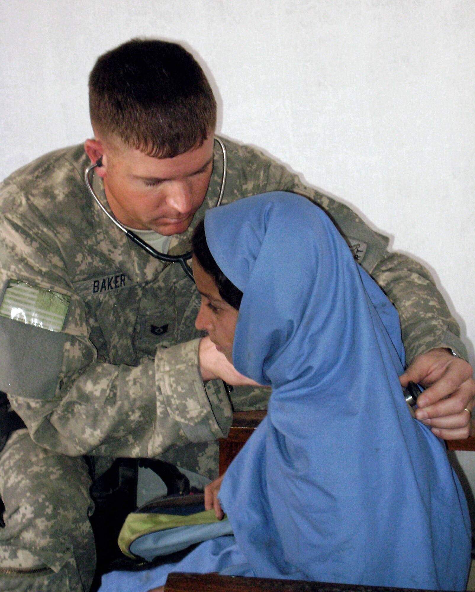 Technical Sgt. Kyle Baker checks the breathing of a student at the Hope of Mother Clinic Feb. 24 in the Surkh Rod District of Afghanistan. Sergeant Baker is a medic with the provincial reconstruction team in Afghanistan's Nangarhar province. (U.S. Air Force photo/Capt. Dustin Hart) 
